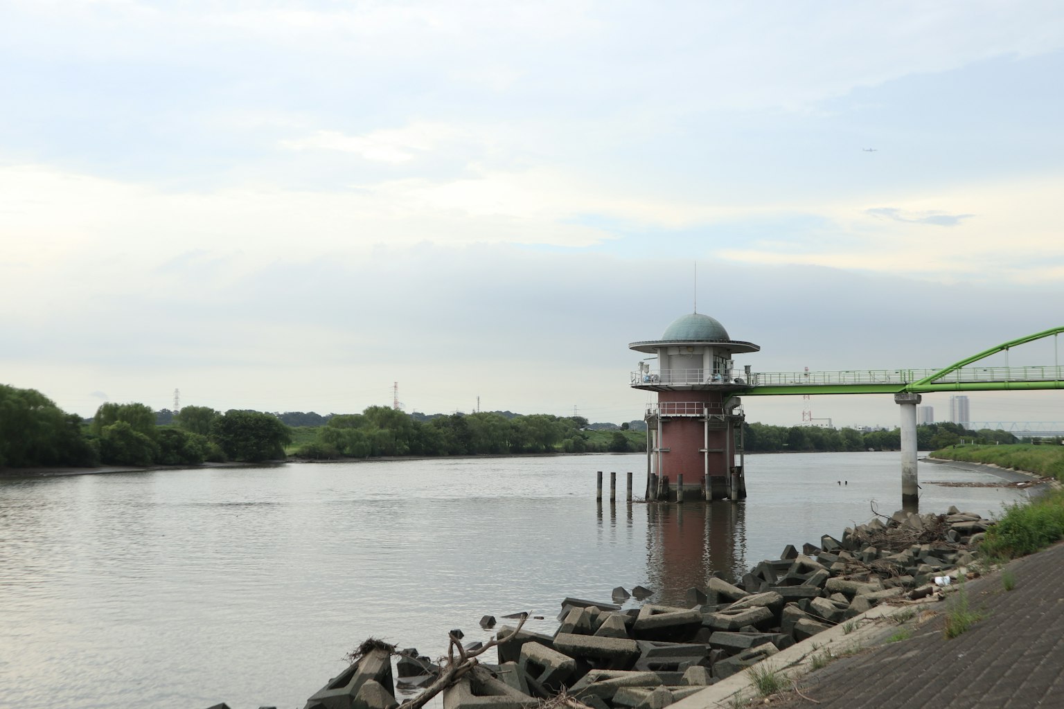 Unique building by the riverbank with surrounding landscape
