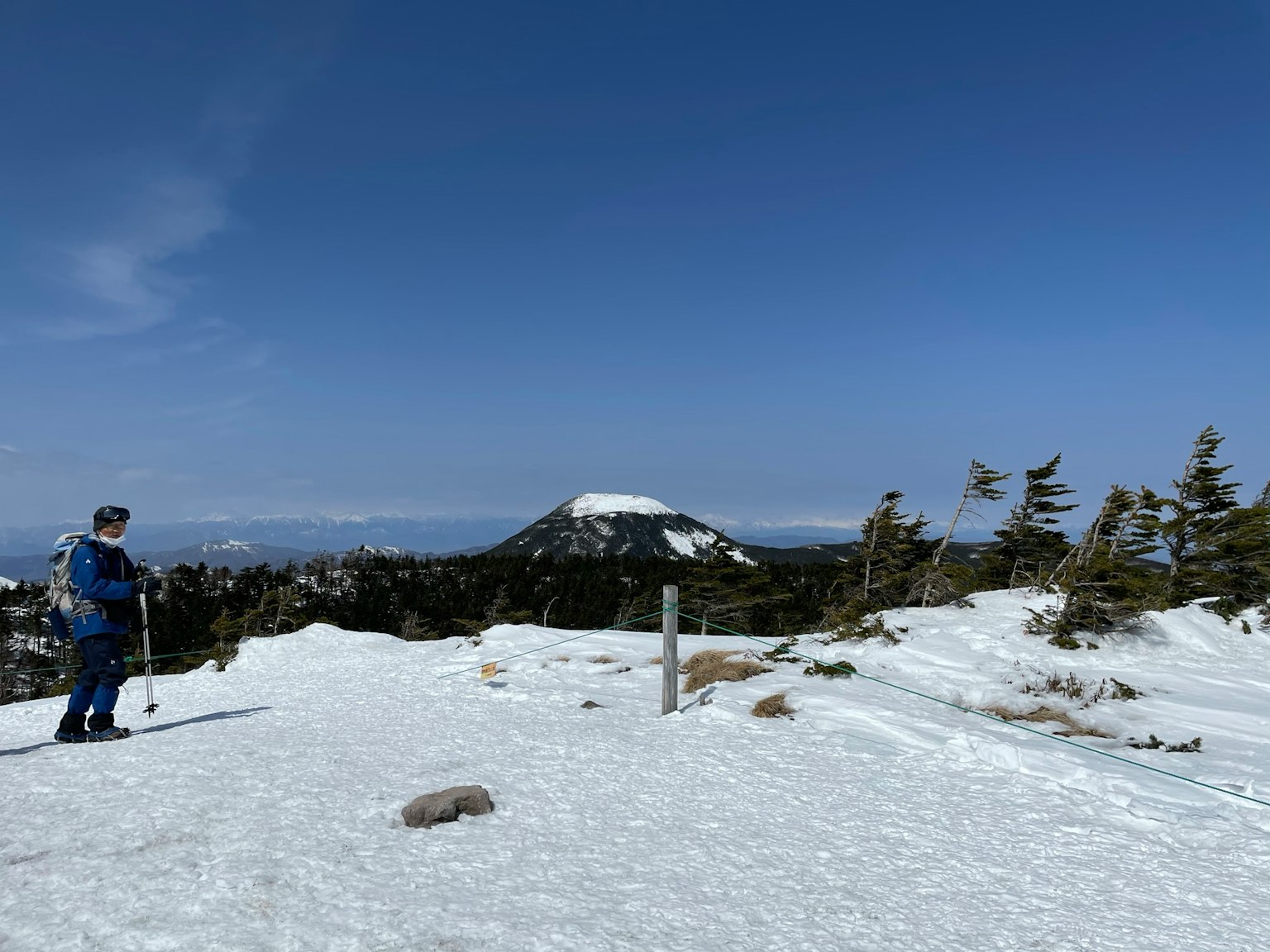 Una persona che scia su una montagna coperta di neve con un cielo blu chiaro