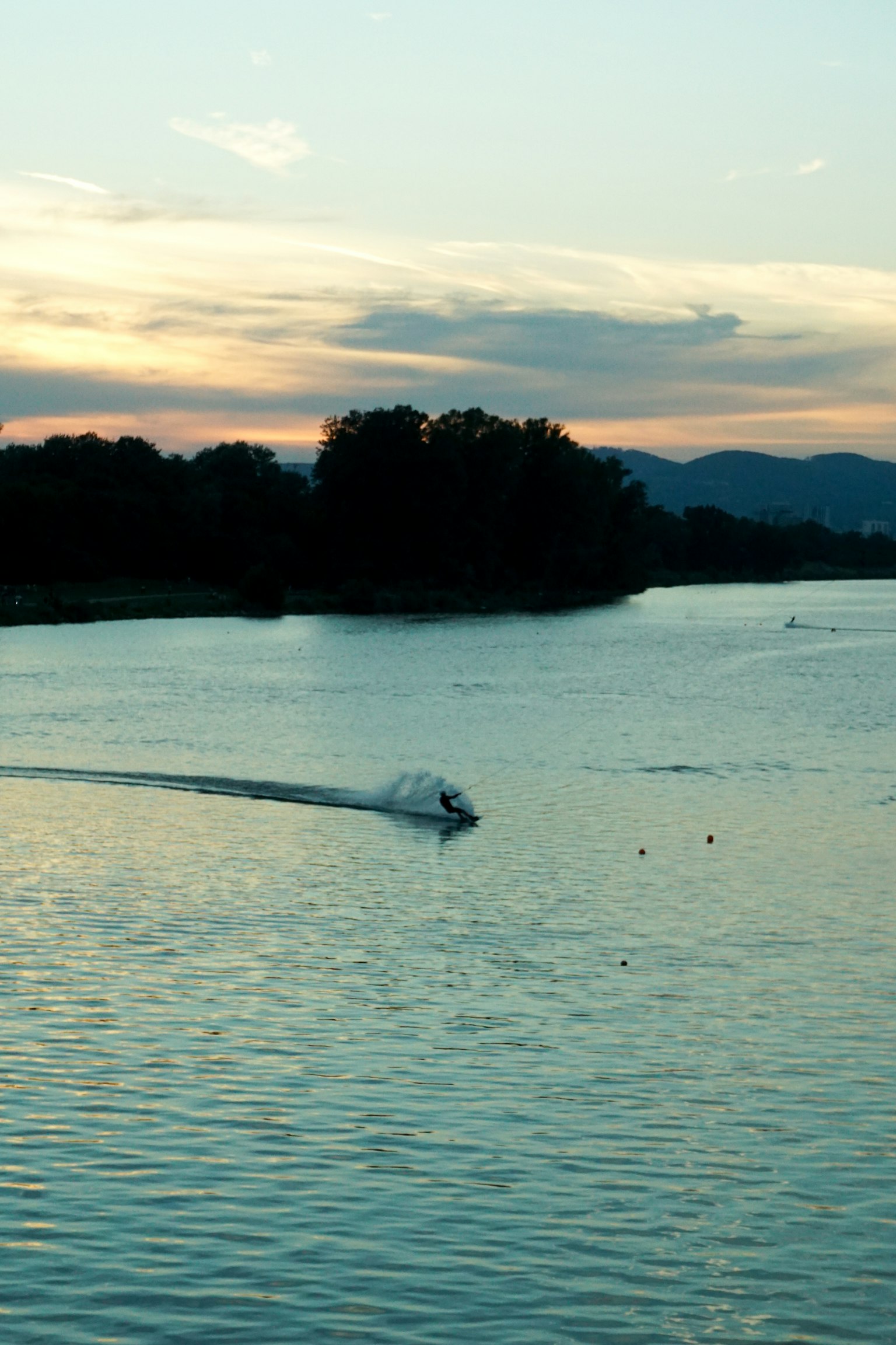 夕焼けの中を進むボートと静かな川の風景