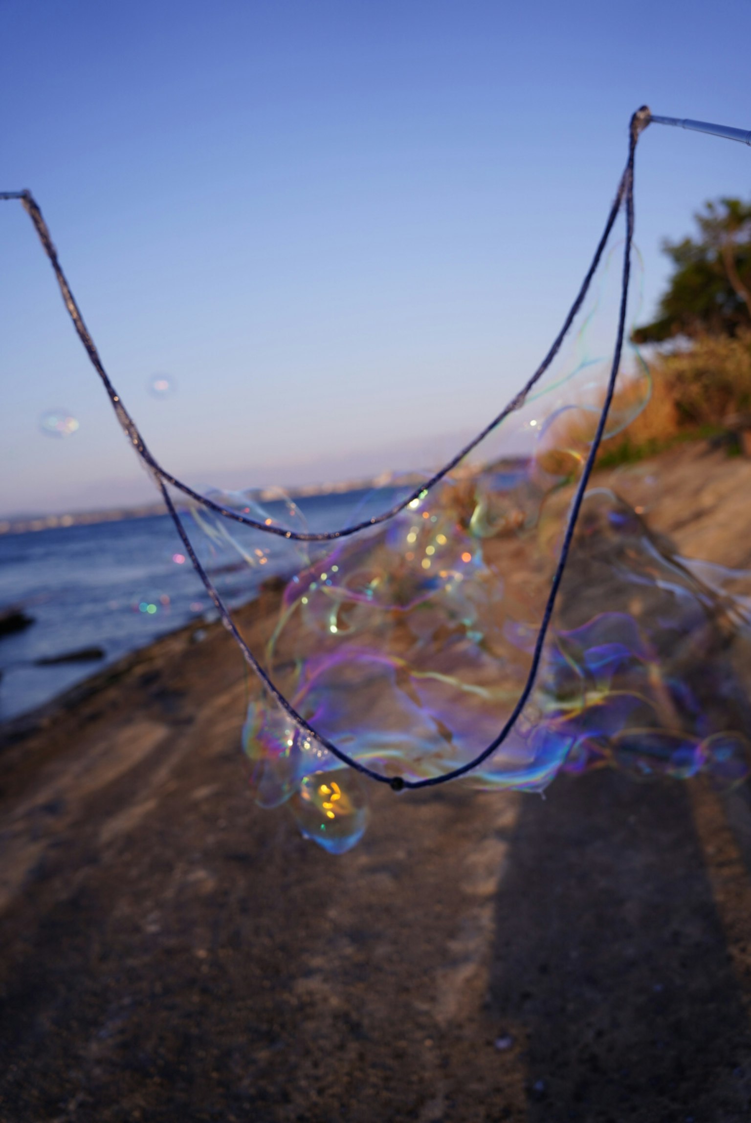 Una gran burbuja de jabón reflejando la luz cerca del mar