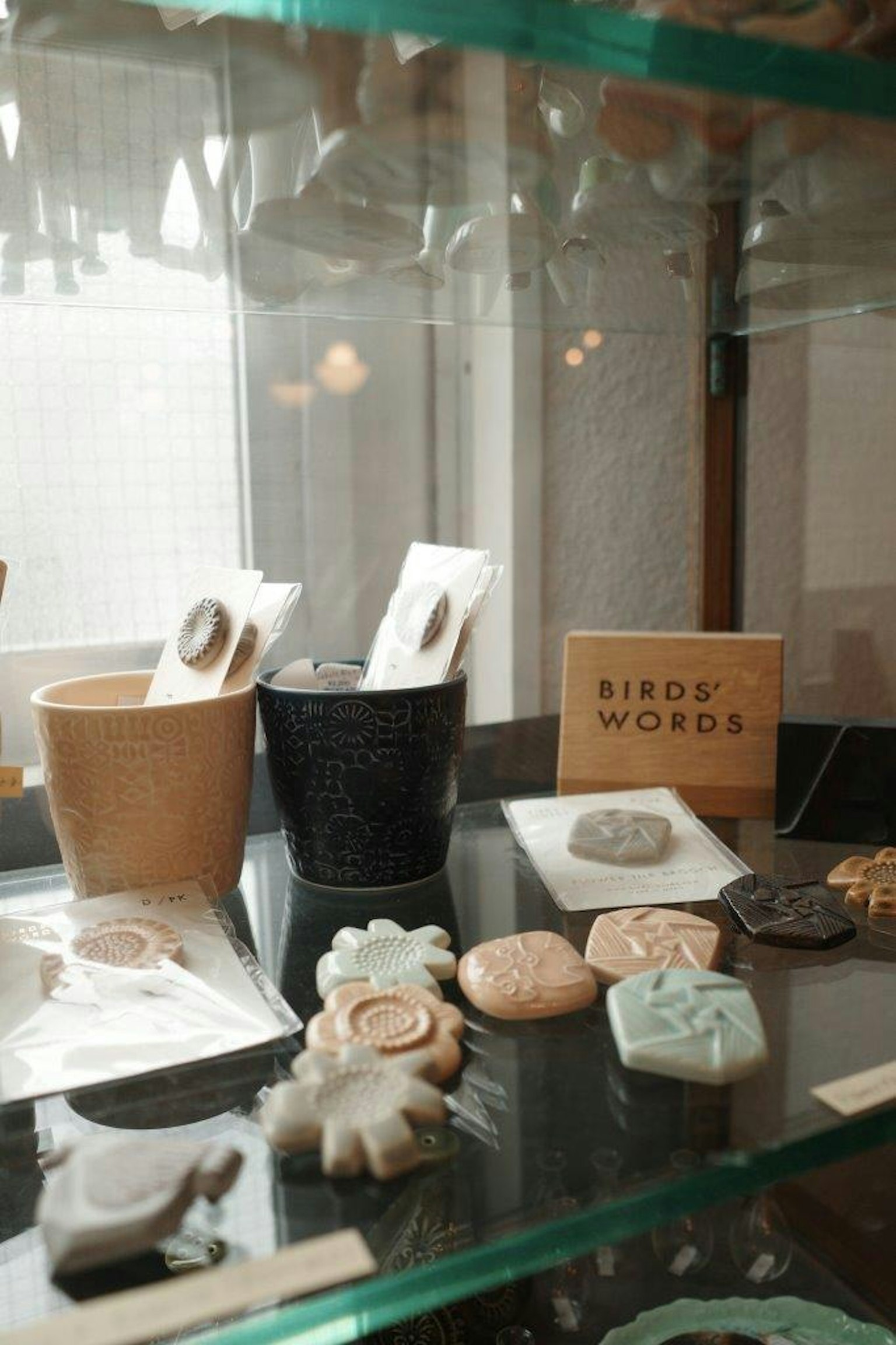 Collection de pots en céramique et d'objets décoratifs exposés dans une vitrine en verre