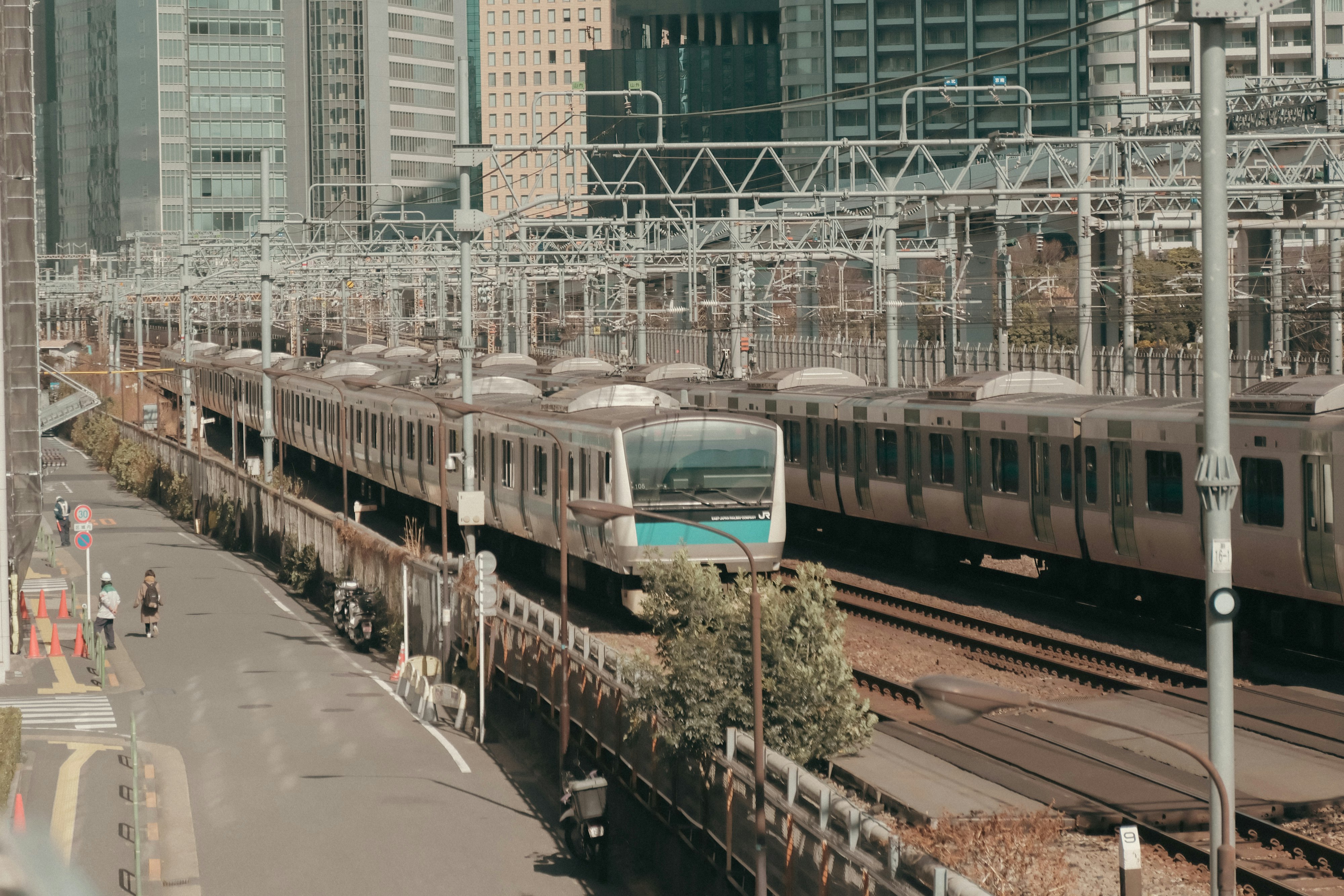 高樓環繞的車站區域，高架鐵路上的列車