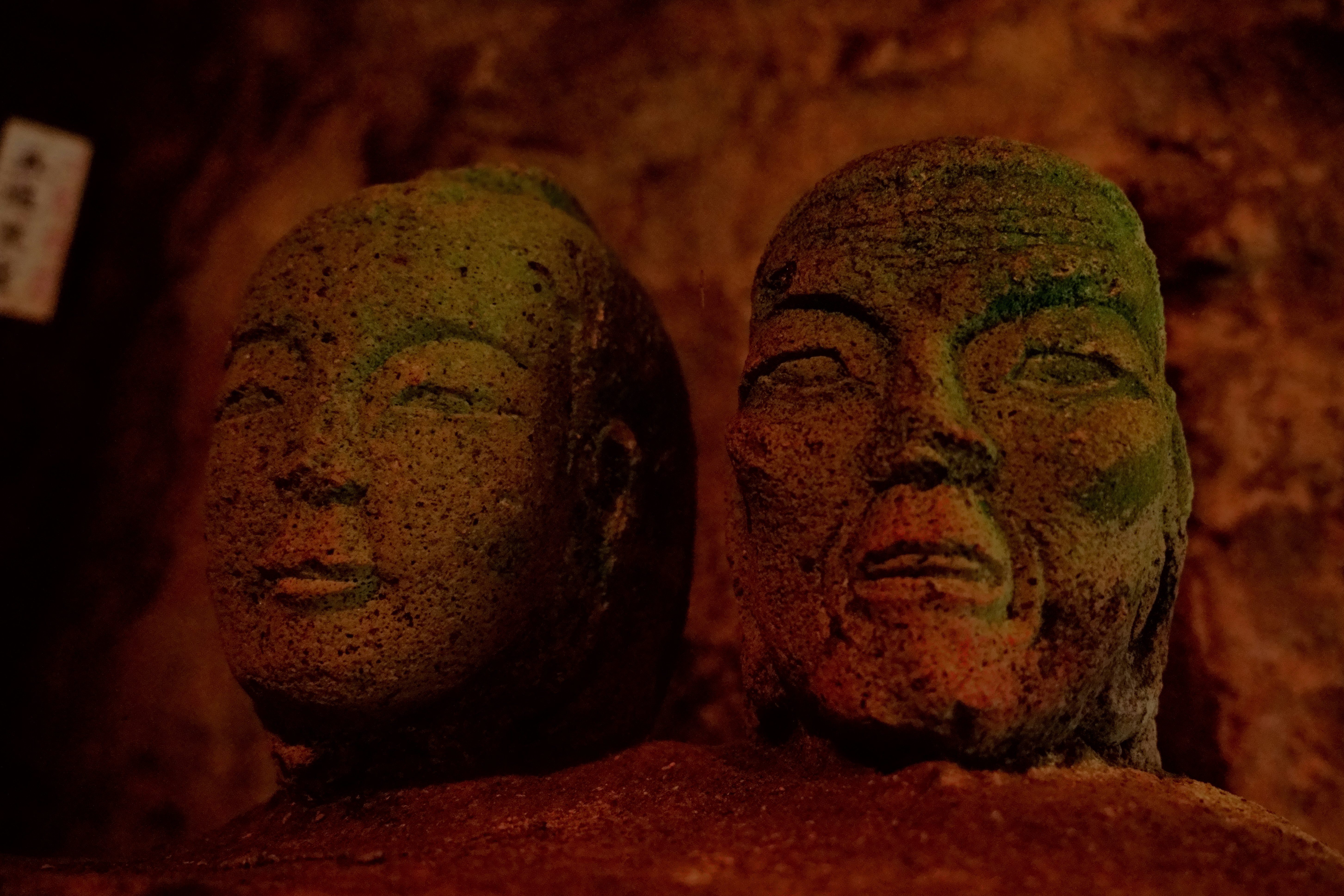 地獄を思わせる赤い背景の石仏の顔