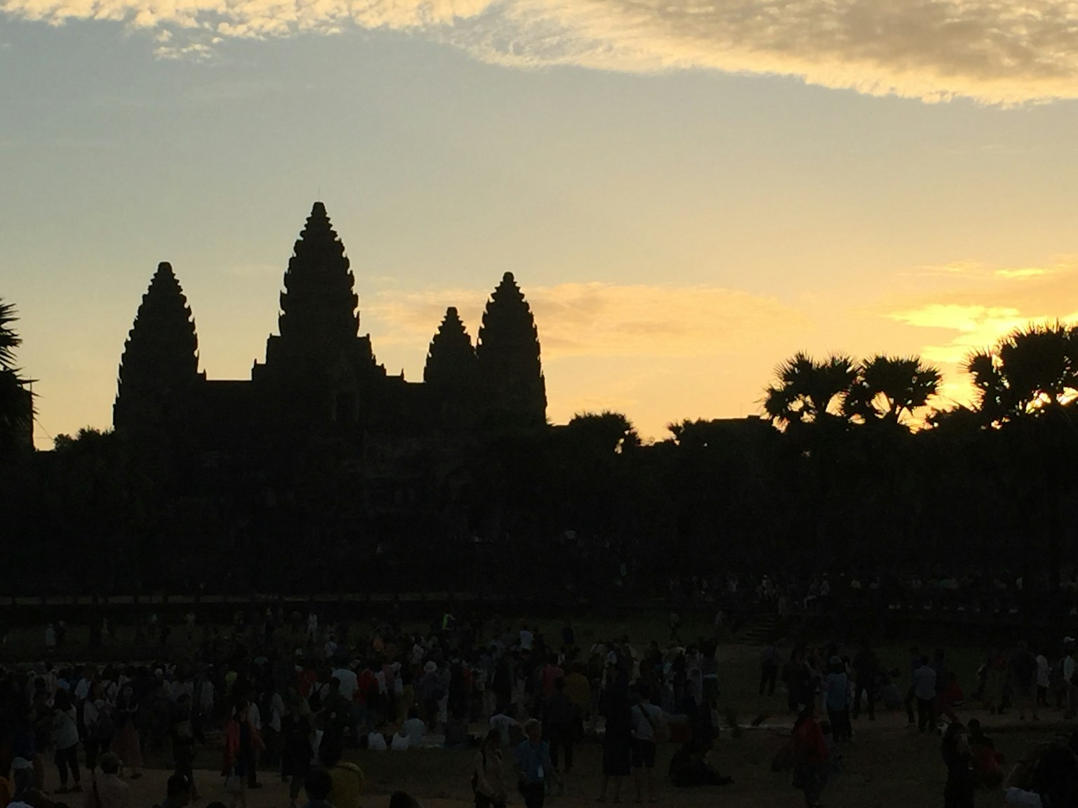 Silhouette di Angkor Wat al tramonto con una folla di turisti