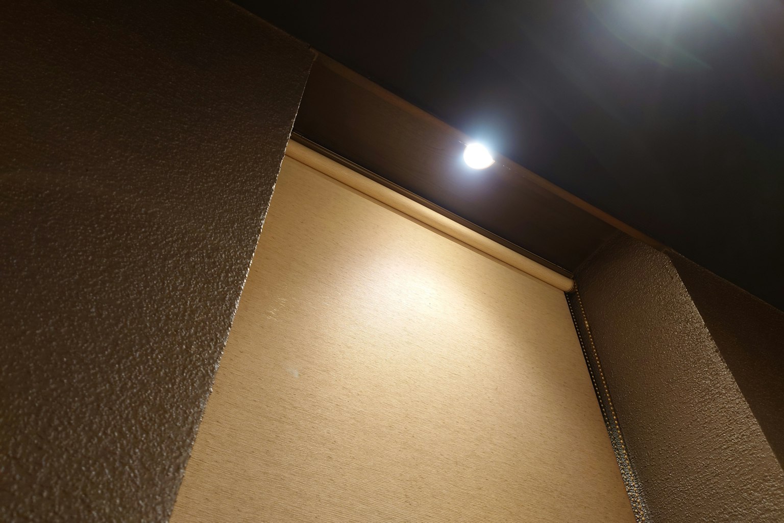 Interior image showing ceiling light and part of the wall