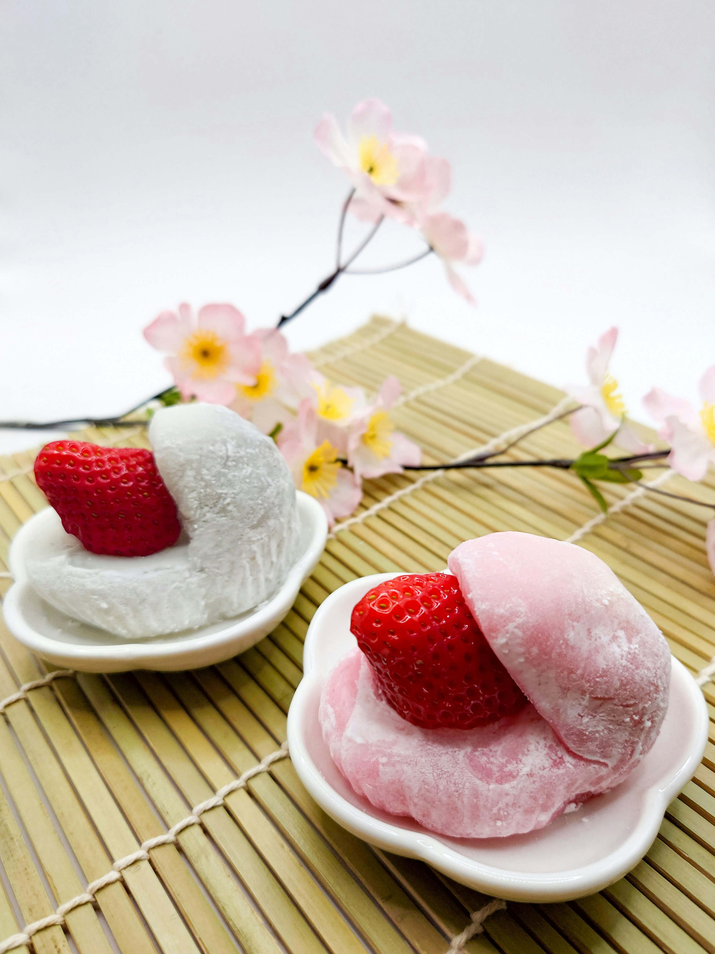 japanisch inspiriertes weißes Dessert mit Erdbeeren und Blumen
