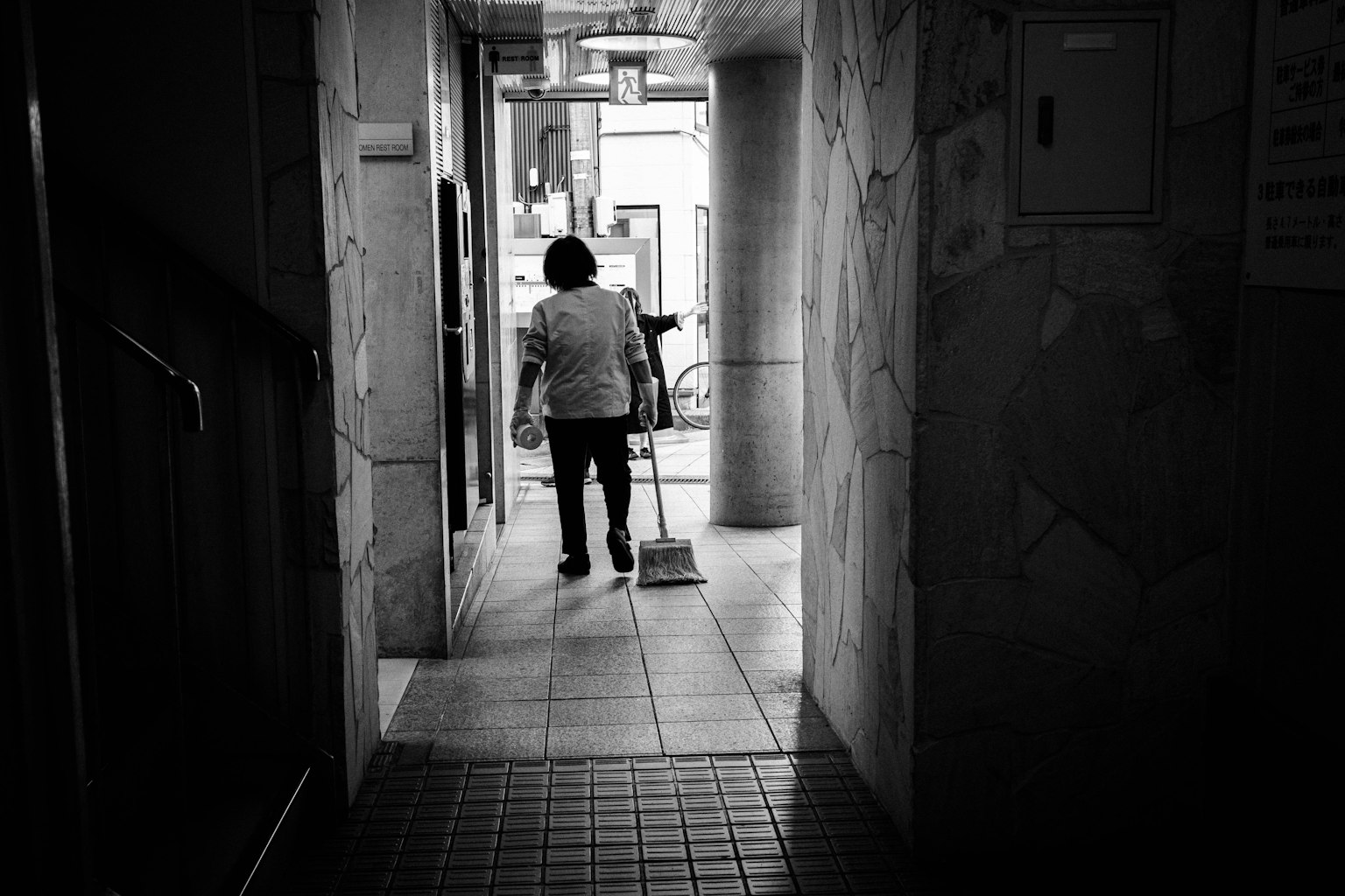 Orang menyapu di lorong yang redup
