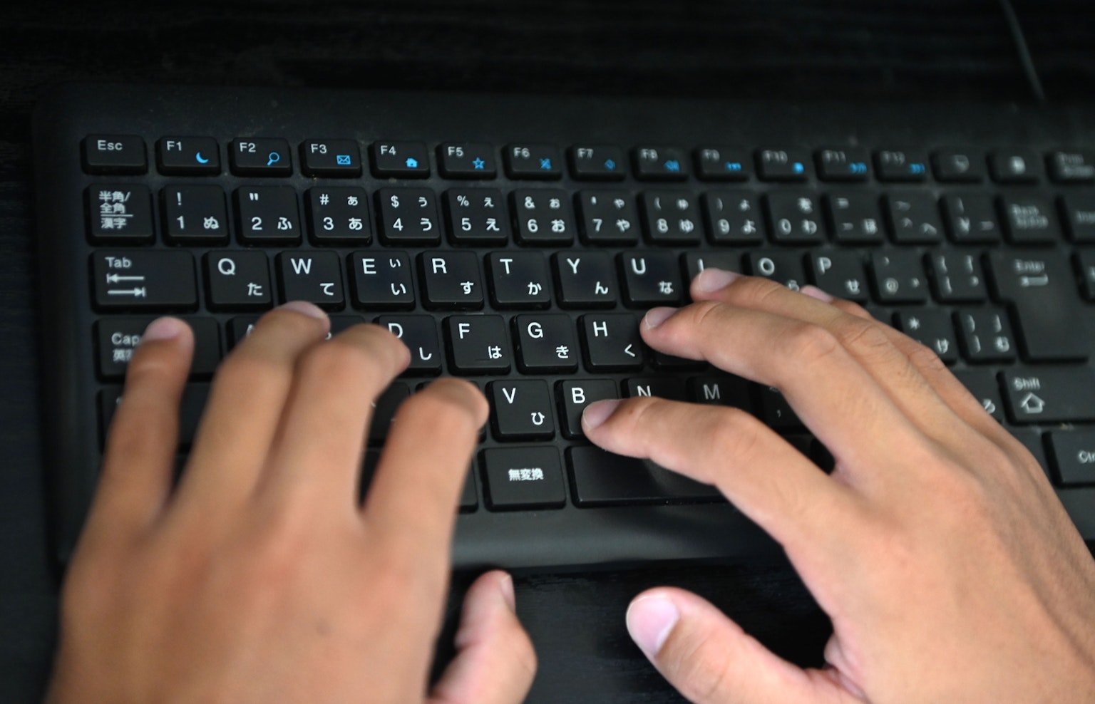 Primer plano de dos manos escribiendo en un teclado