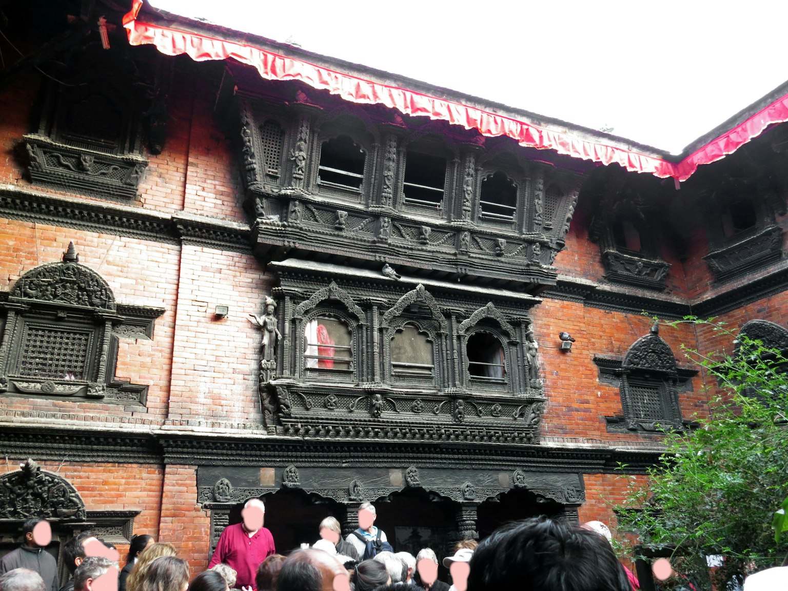 Bâtiment de style architectural népalais traditionnel avec des personnes rassemblées