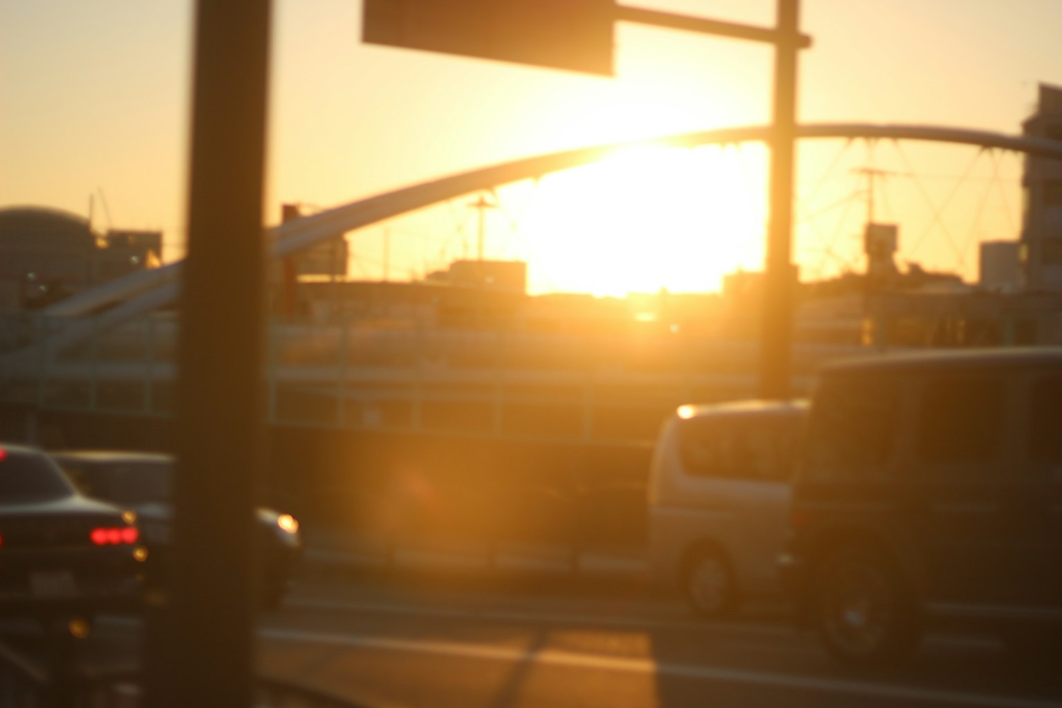 Cityscape with sunset and bridge visible through traffic