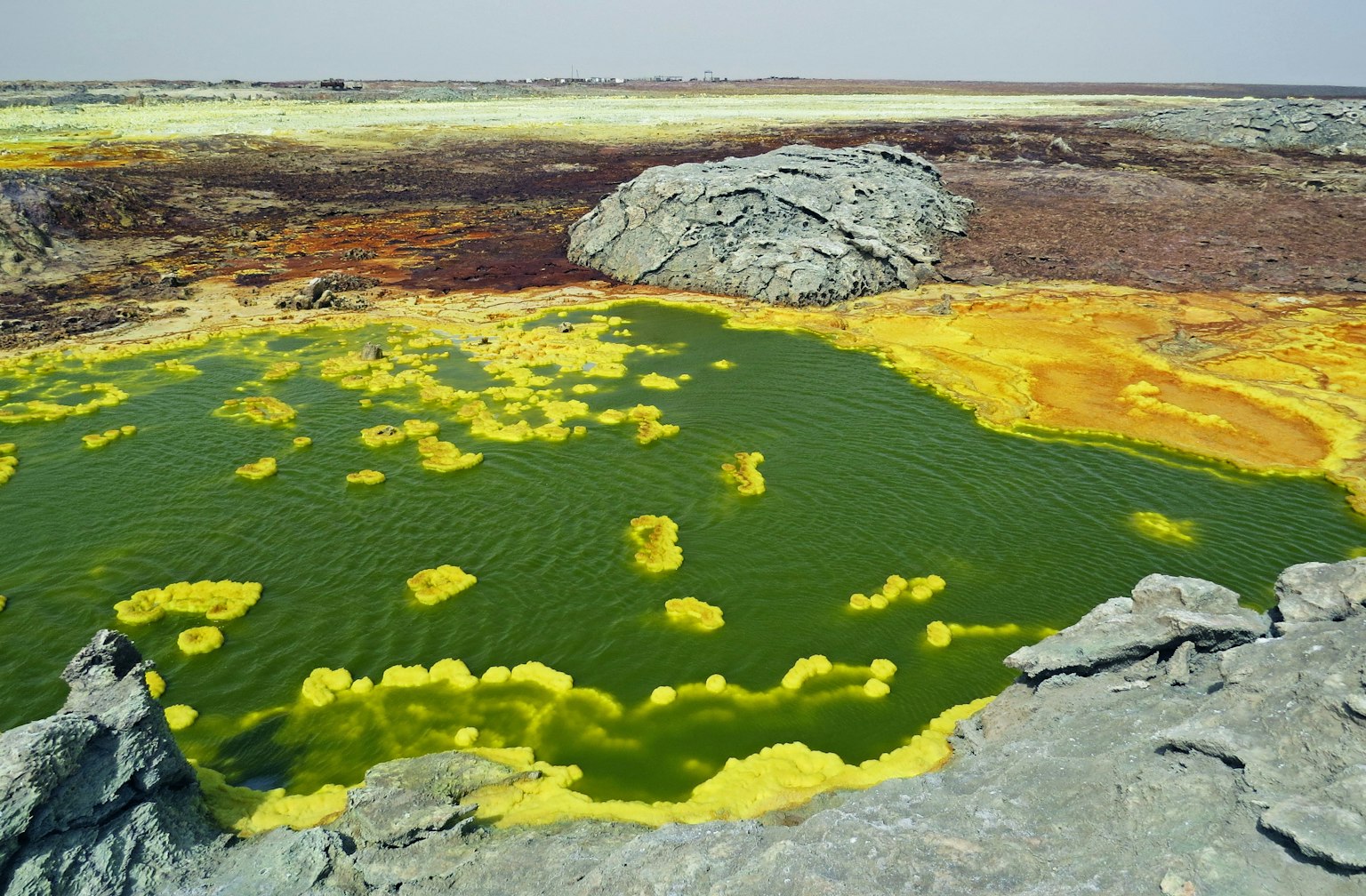 Paisaje desolado con agua verde y minerales amarillos