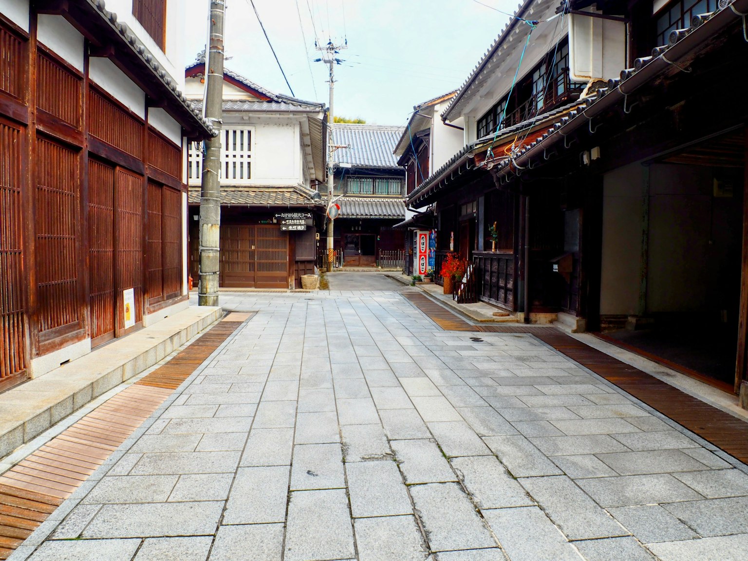 Quiet stone-paved street lined with traditional Japanese buildings