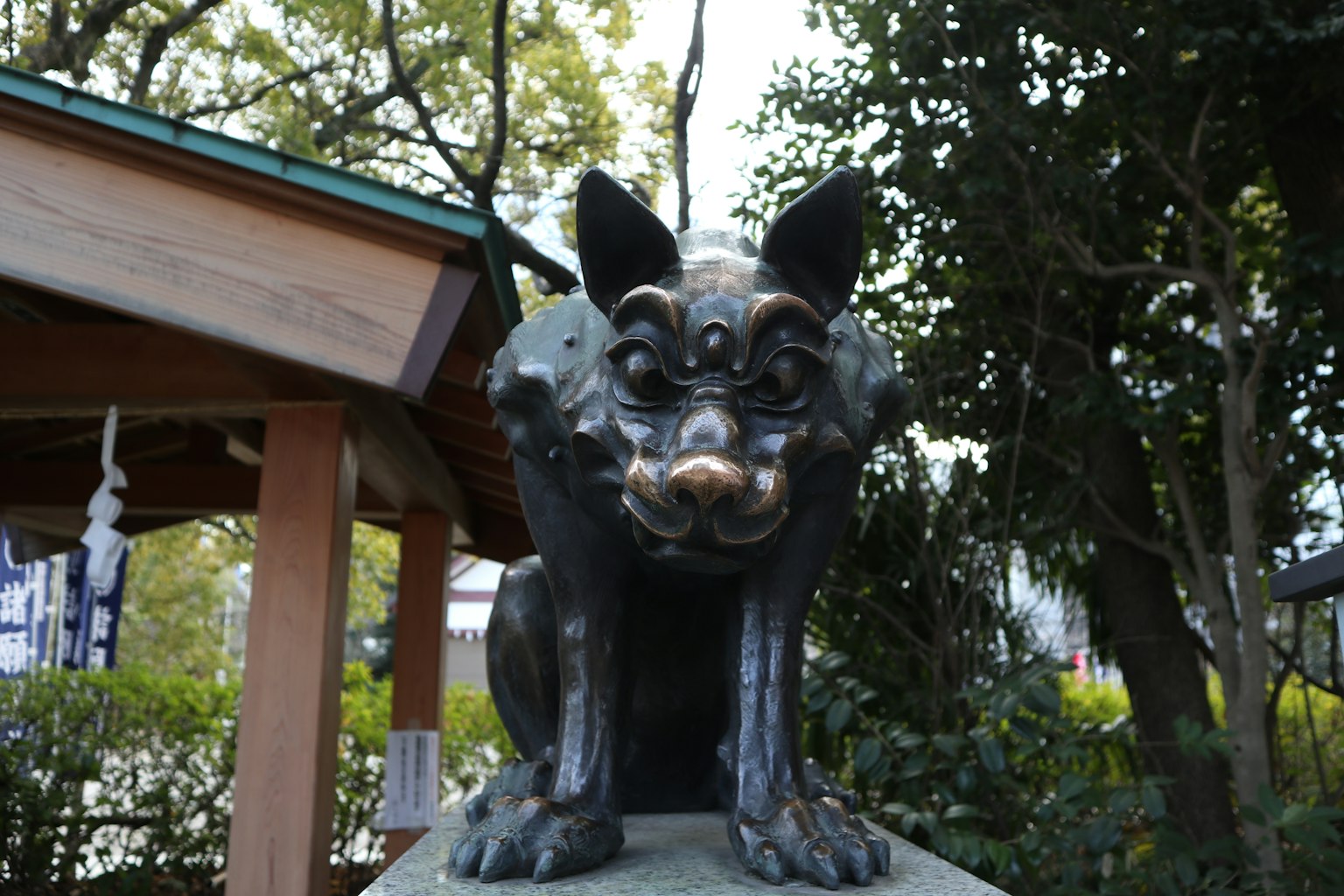 Escultura de perro negro frente a un santuario