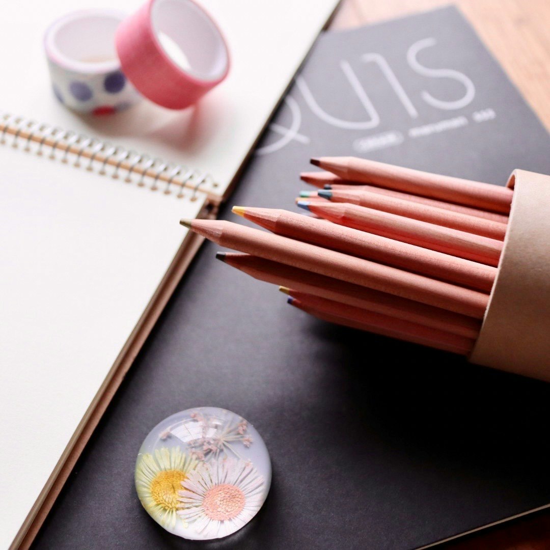 still life of pencils and a notebook on a desk