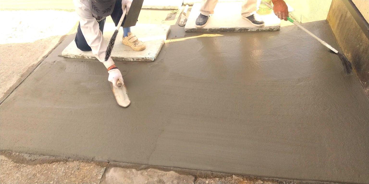 Image d'un travailleur appliquant du béton sur une surface