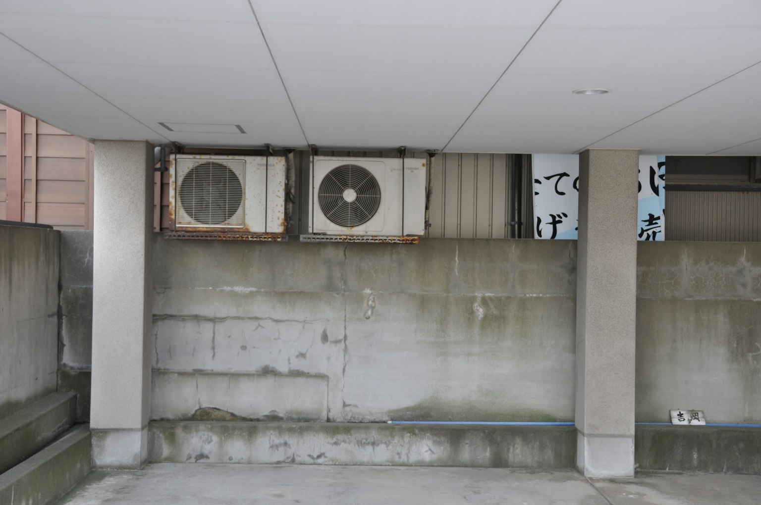 Image d'anciennes unités de climatisation montées sur un mur en béton