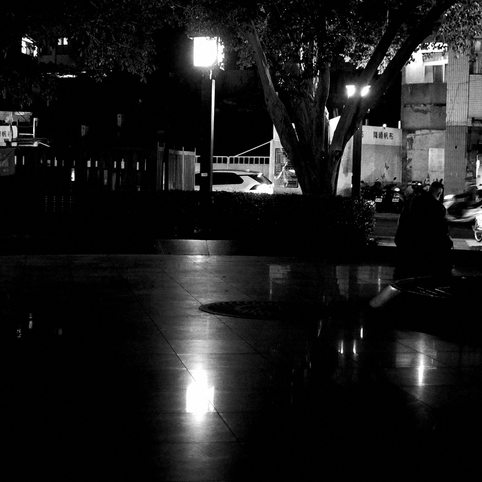 夜の公園の静かな風景 人々が座っている 様々な光が反射している