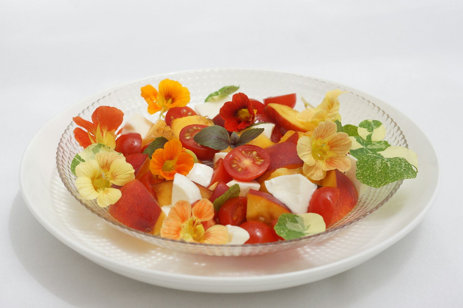 Salad buah berwarna-warni dihiasi dengan bunga yang bisa dimakan