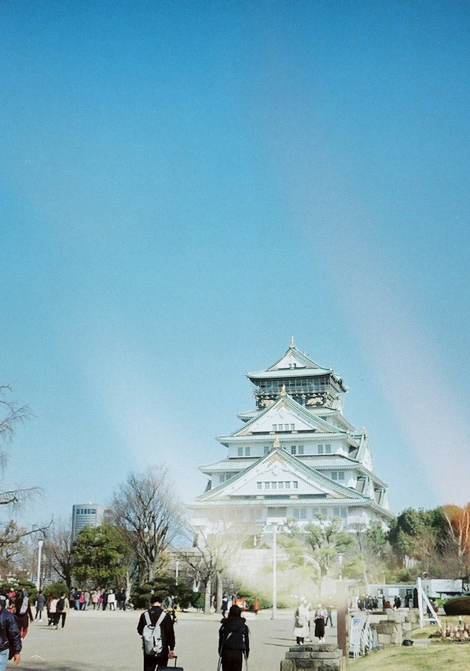 Vista bellissima del castello di Osaka sotto un cielo blu chiaro con visitatori
