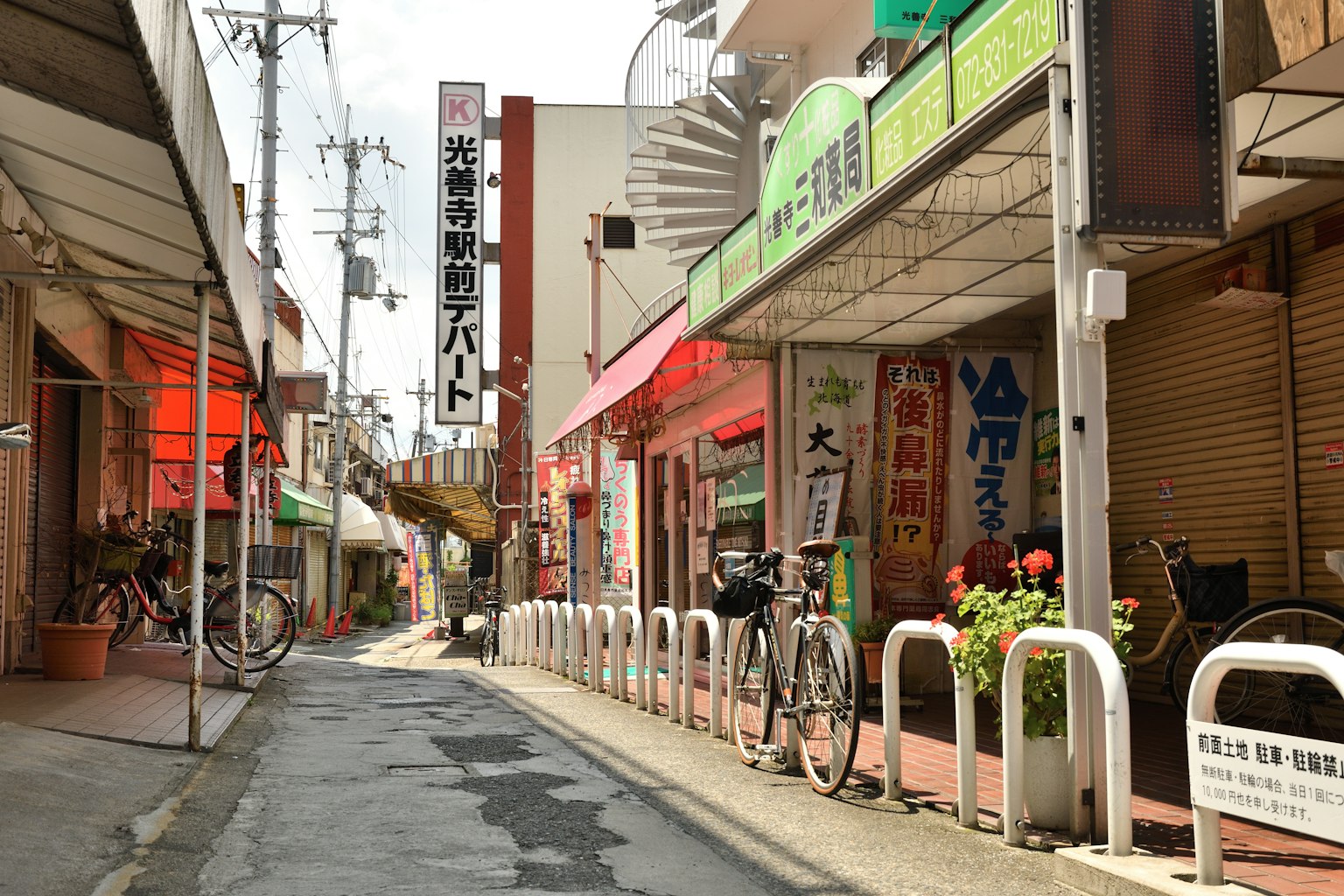 Ruhige japanische Einkaufsstraßen-Gasse mit Fahrrädern und bunten Schildern