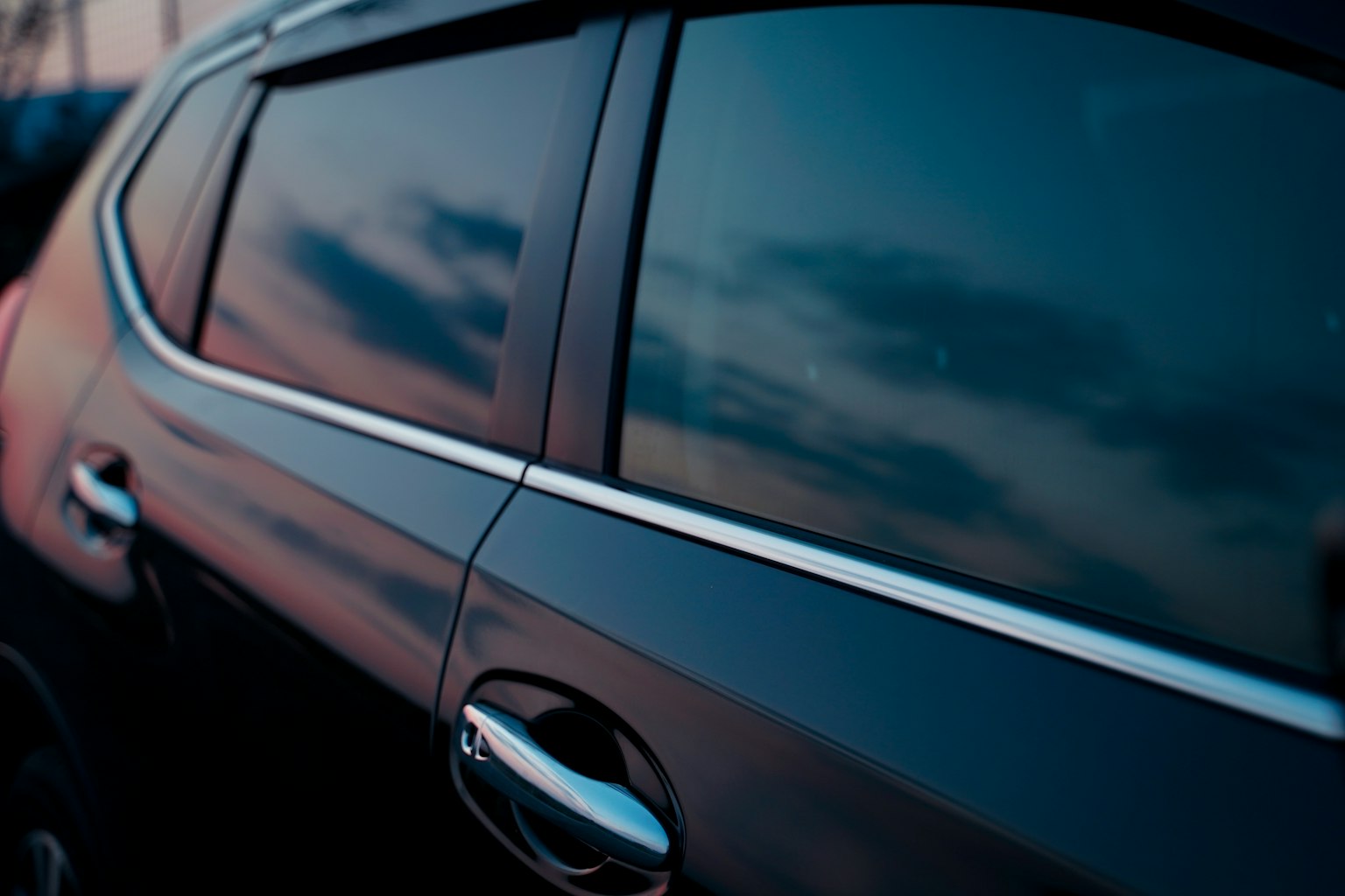 Reflection of the sky and clouds on a black car window