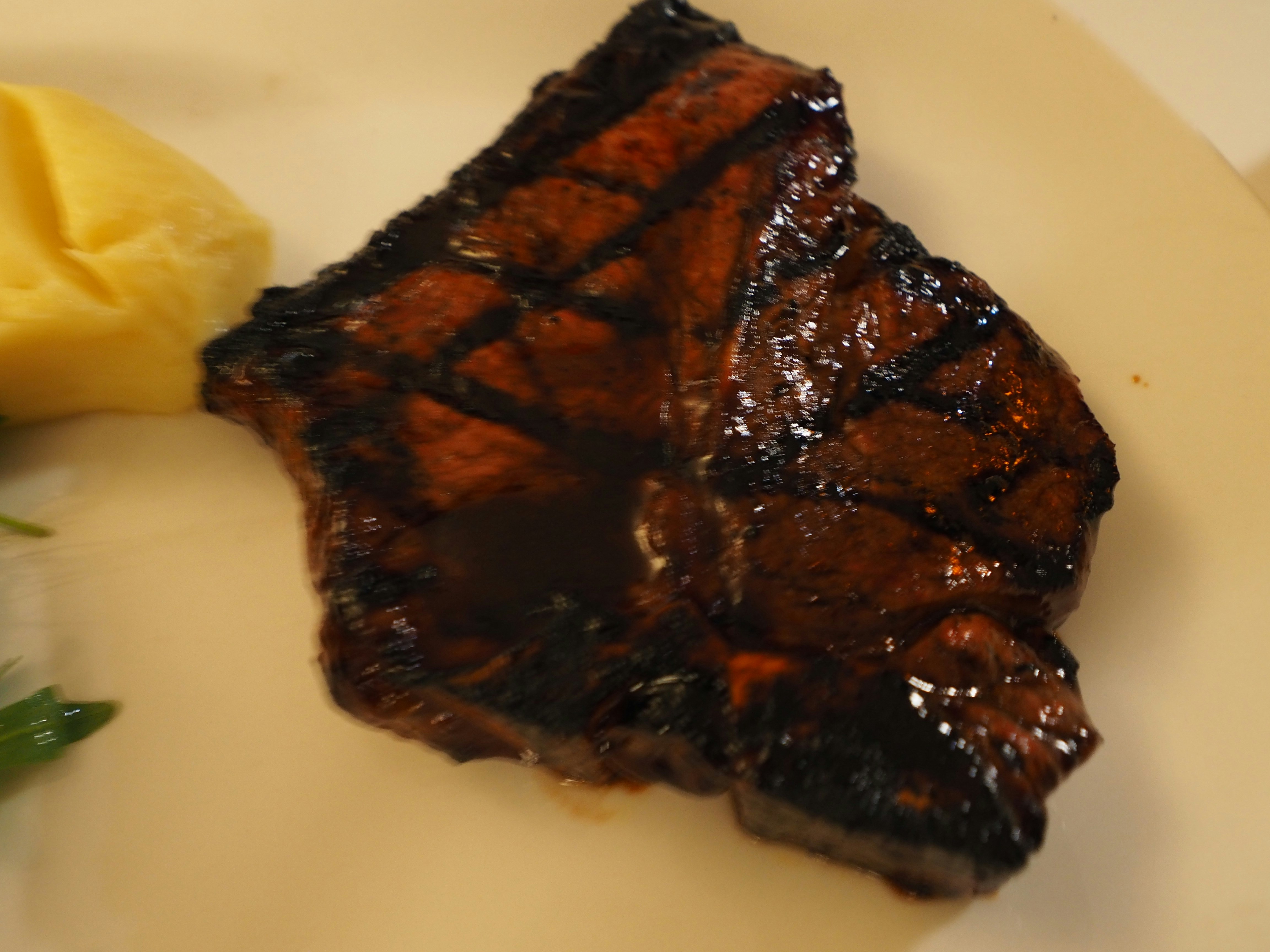 plated grilled meat with butter and herbs