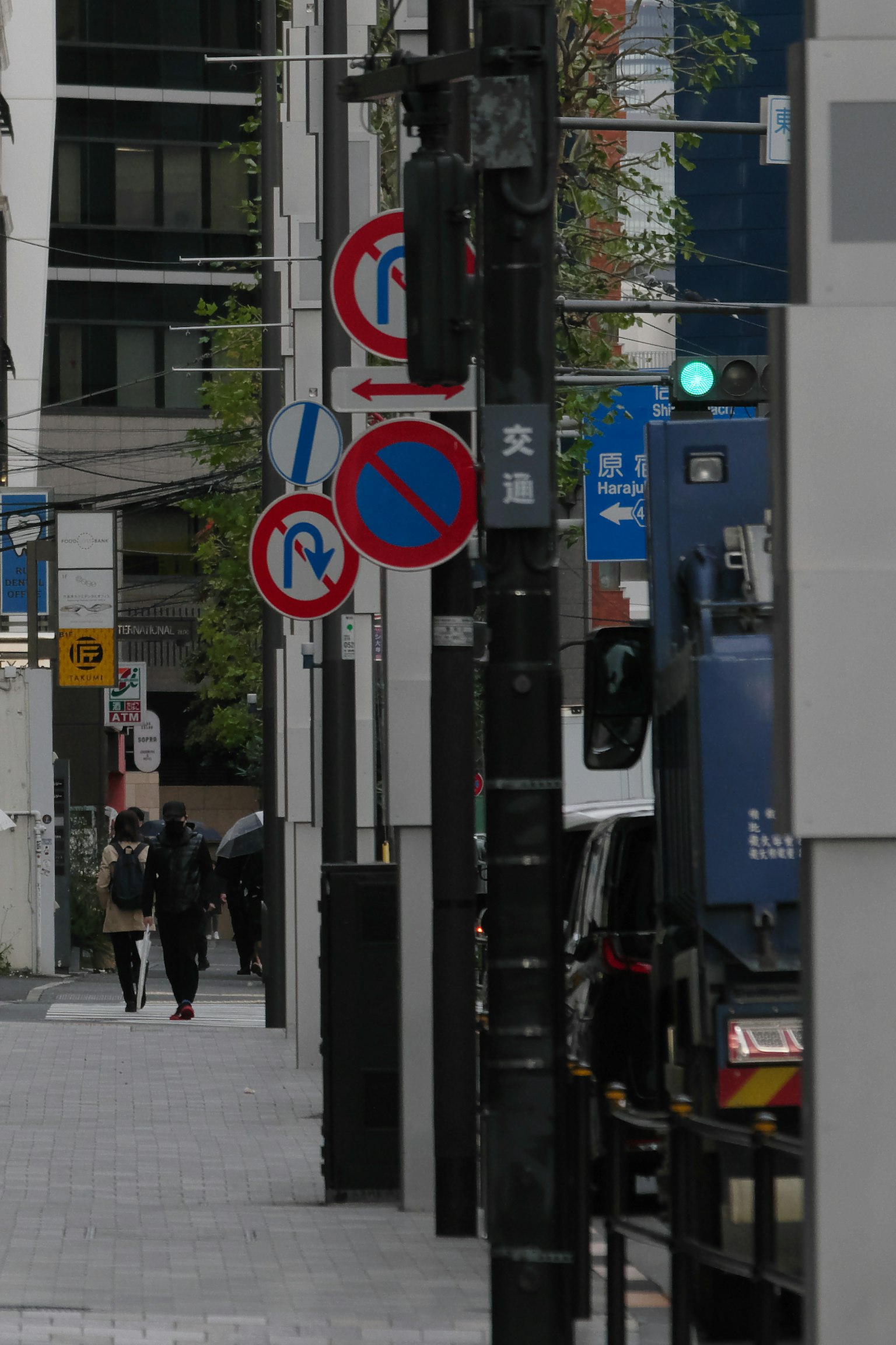 Straßenszene mit Verkehrsschildern und Fußgängern