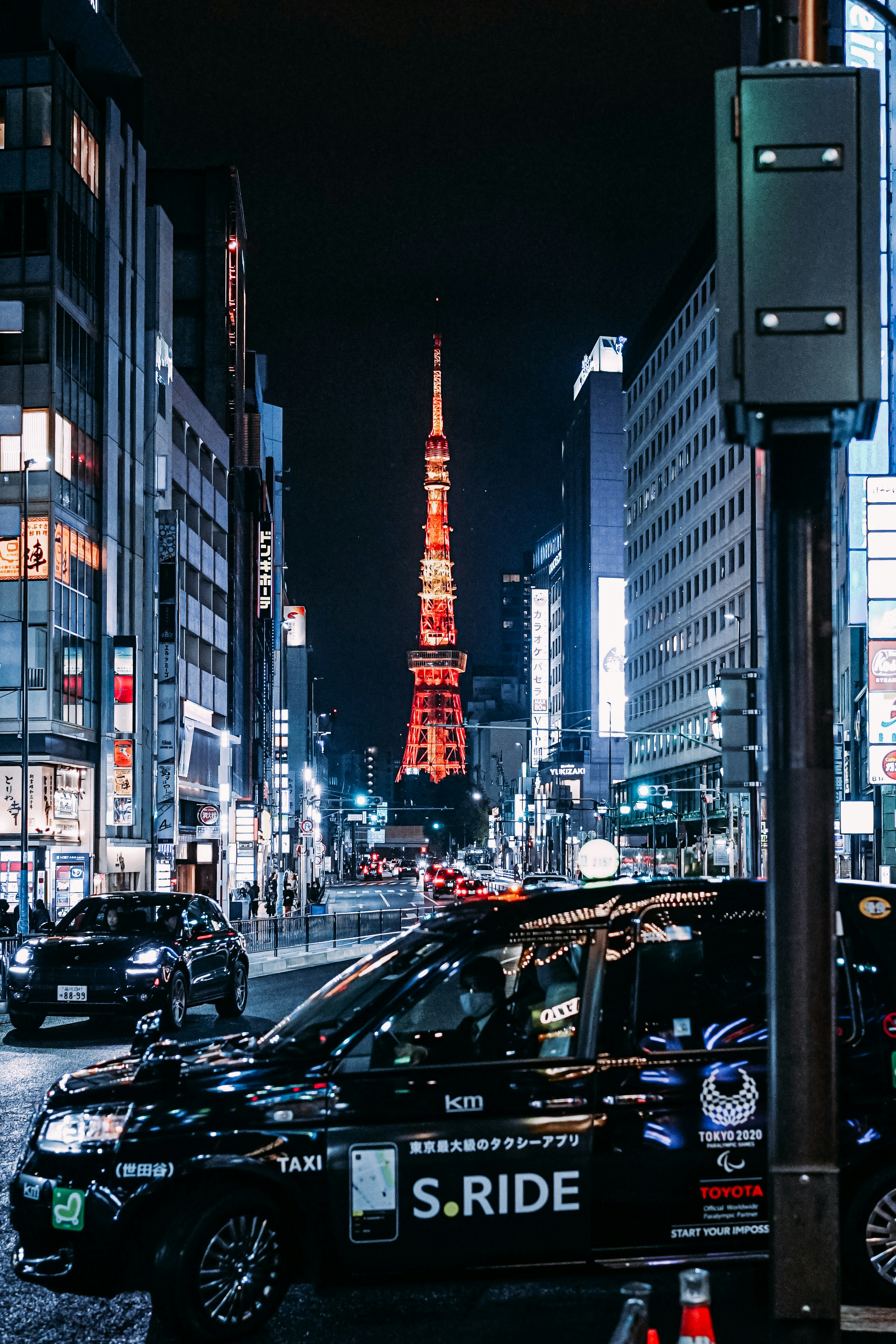 Nächtliche Straßenszene mit Blick auf den Tokyo Tower entlang einer Hauptstraße