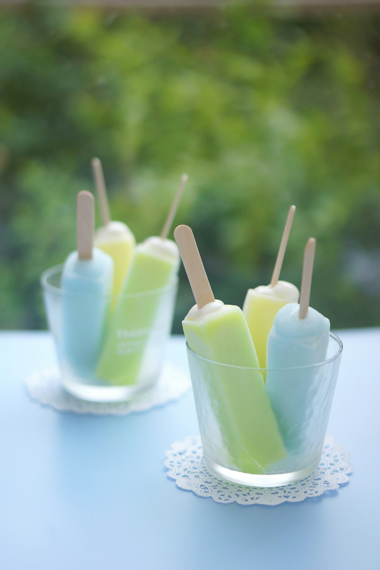 Paletas coloridas en vasos transparentes con palitos de madera