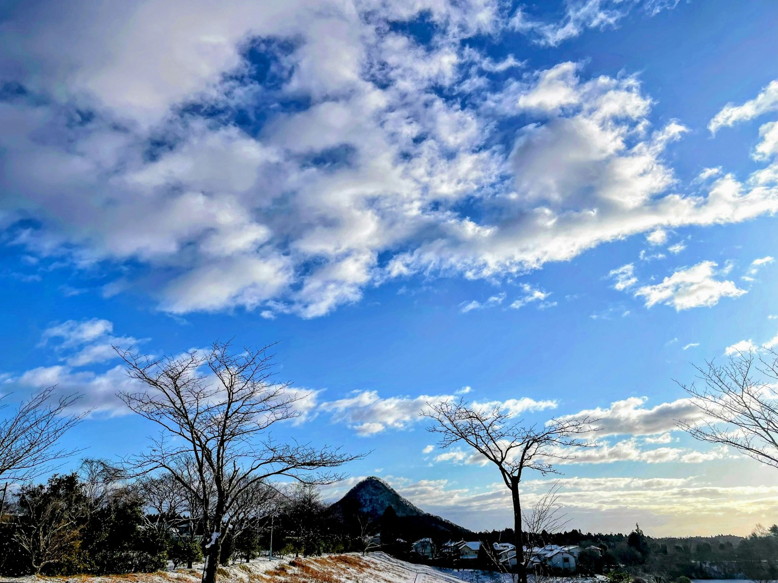 Vista escénica del cielo azul con nubes blancas y montañas distantes
