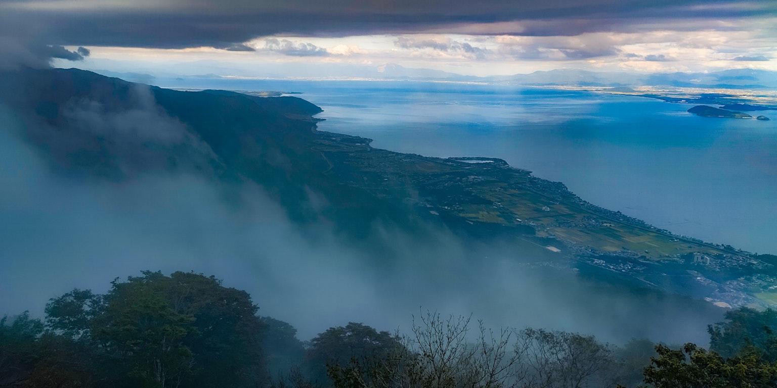 Hermosa vista de montañas y mar envueltos en niebla