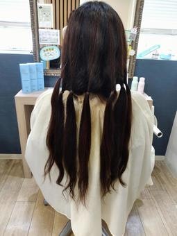 mujer de pelo largo vista desde atrás en un salón de belleza