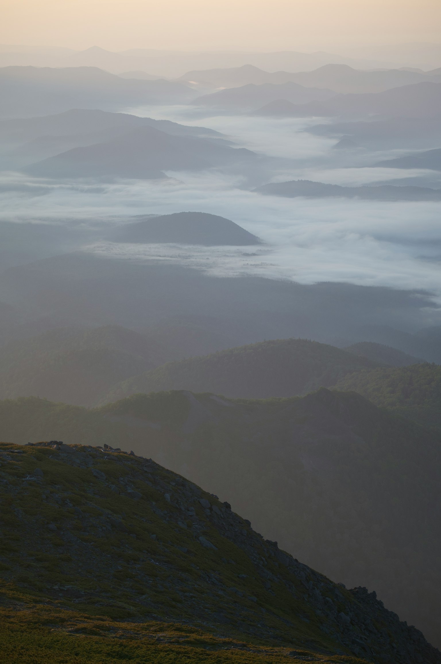 Eine Landschaft mit nebelbedeckten Bergen während der Dämmerung, die natürliche Schönheit zeigt