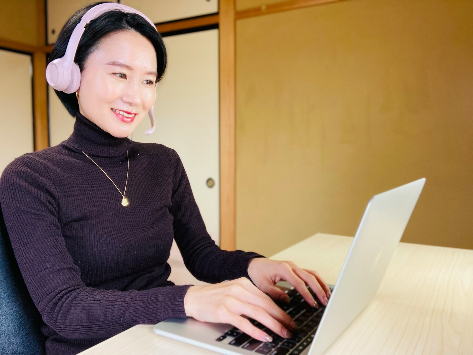 Woman wearing headphones working on a laptop