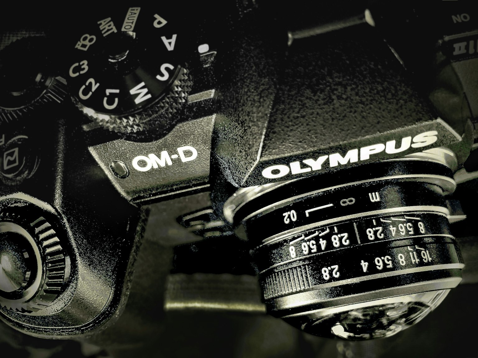 Gambar close-up kamera Olympus OM-D yang menunjukkan lensa dan dials