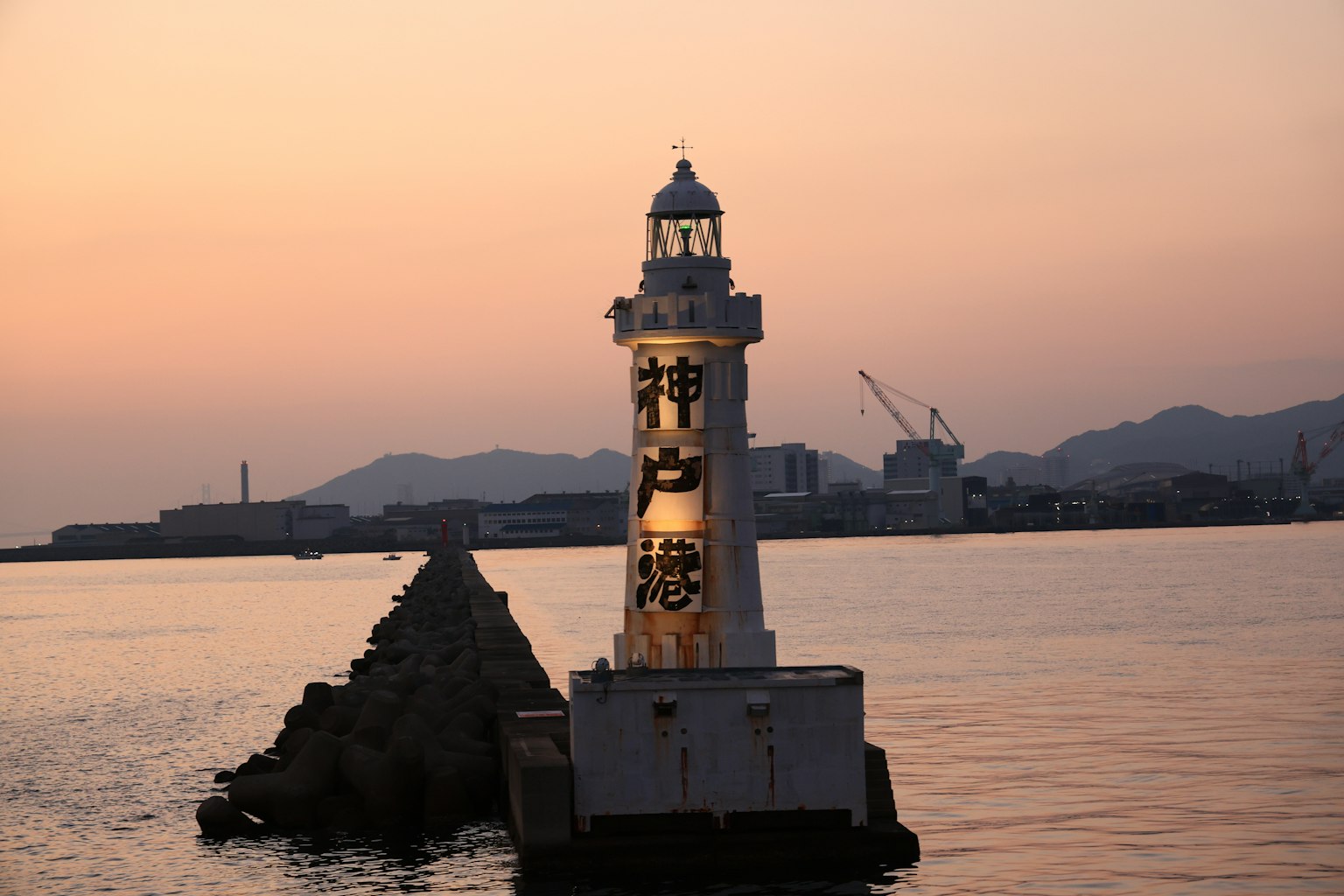Faro de pie en el atardecer con muelle circundante