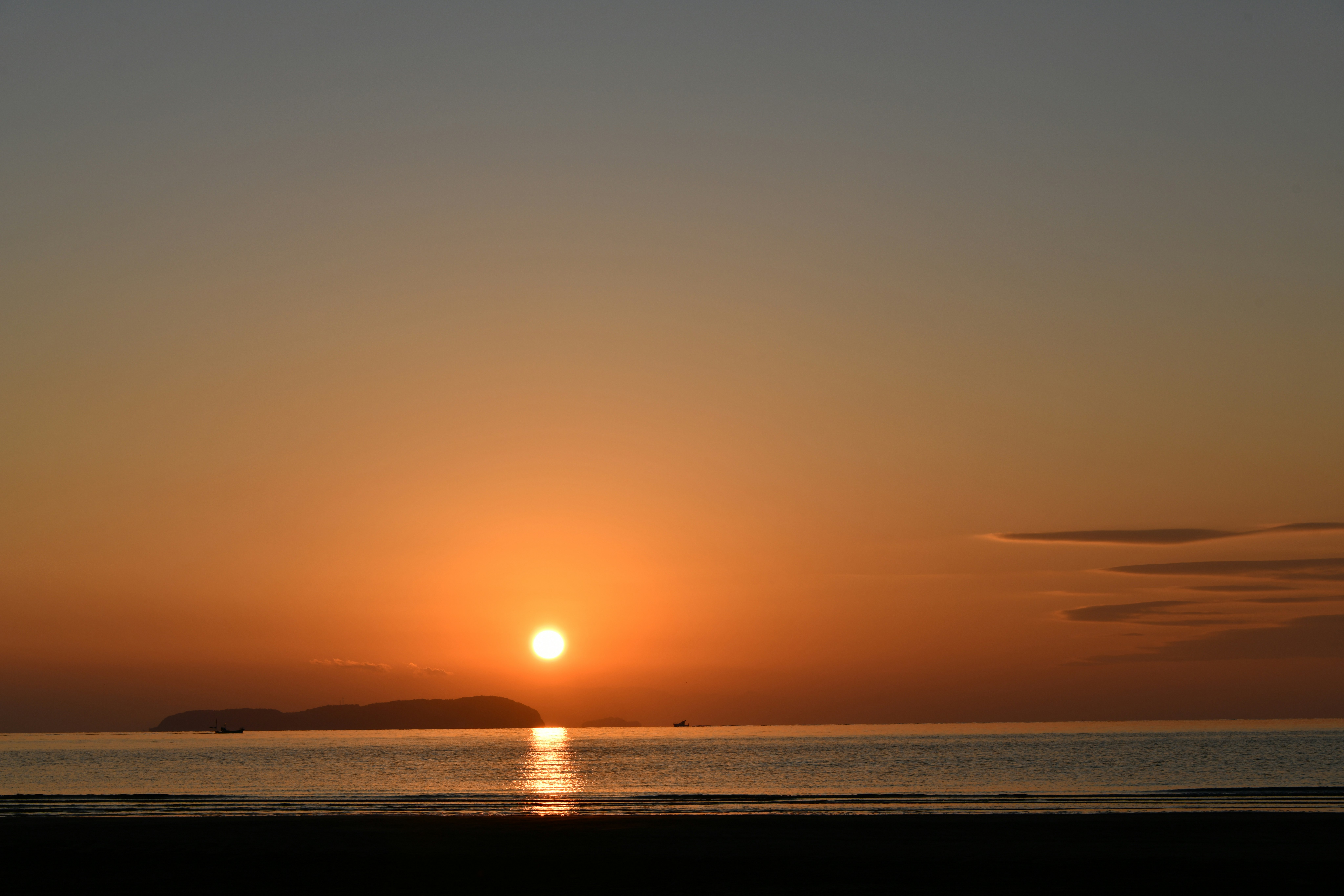 夕日に照らされる海辺の水平線