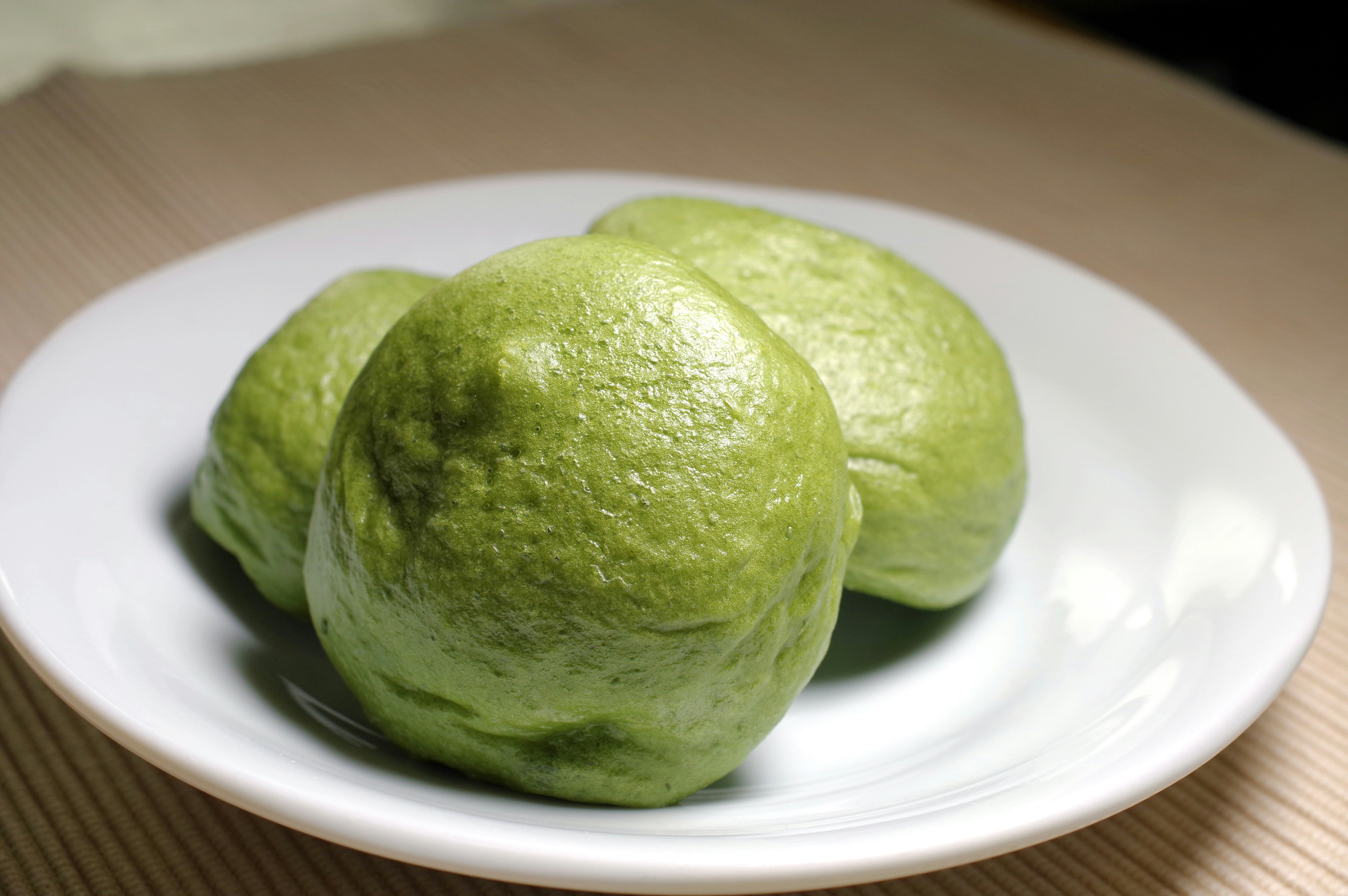 抹茶色の和菓子が白い皿にのった写真