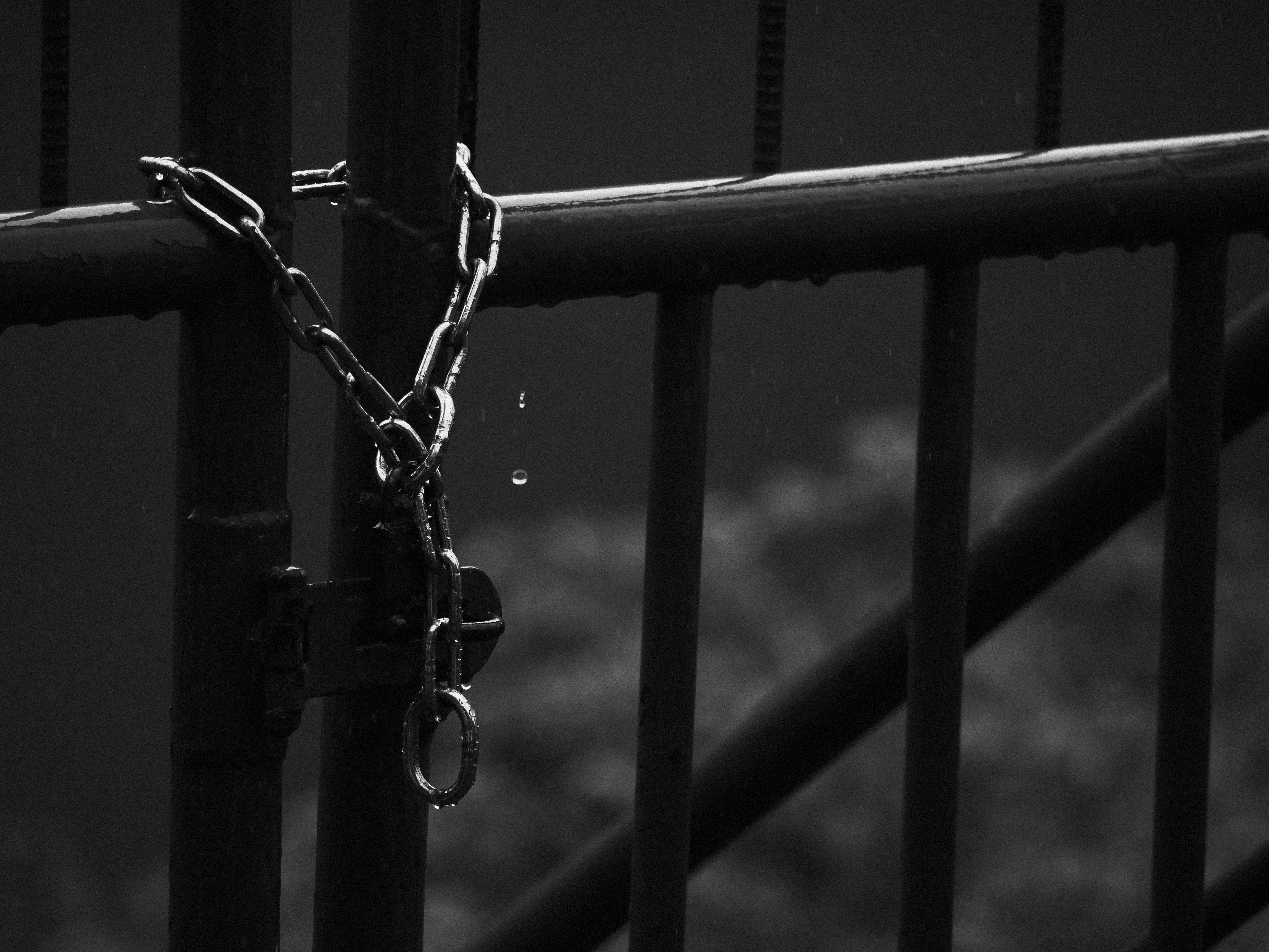 dark outdoor fence with black chain and railing