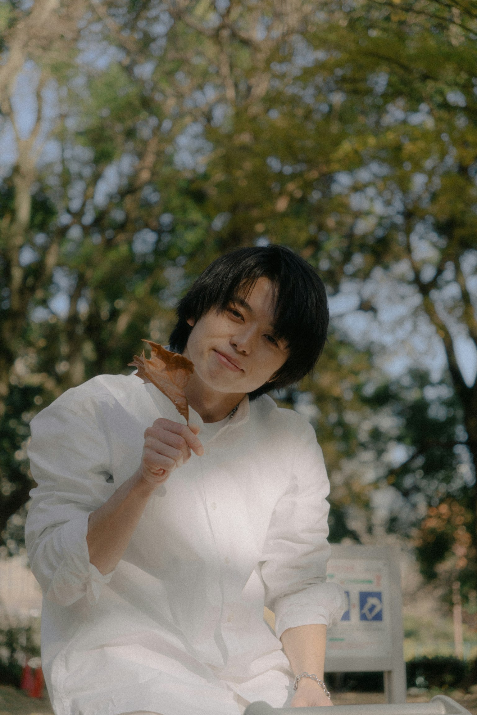 Young man smiling in a park holding food