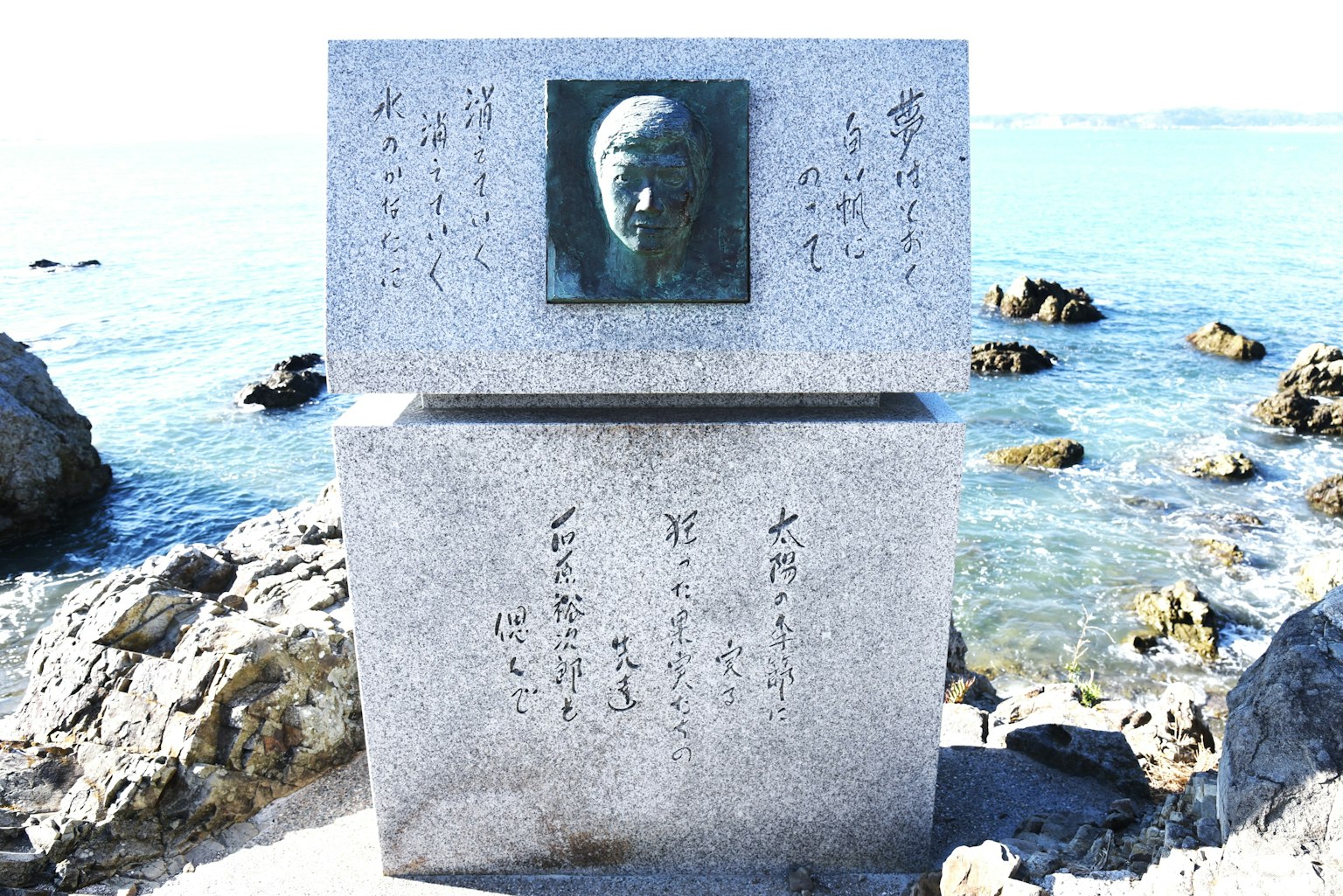 海邊的石碑上有面部雕刻