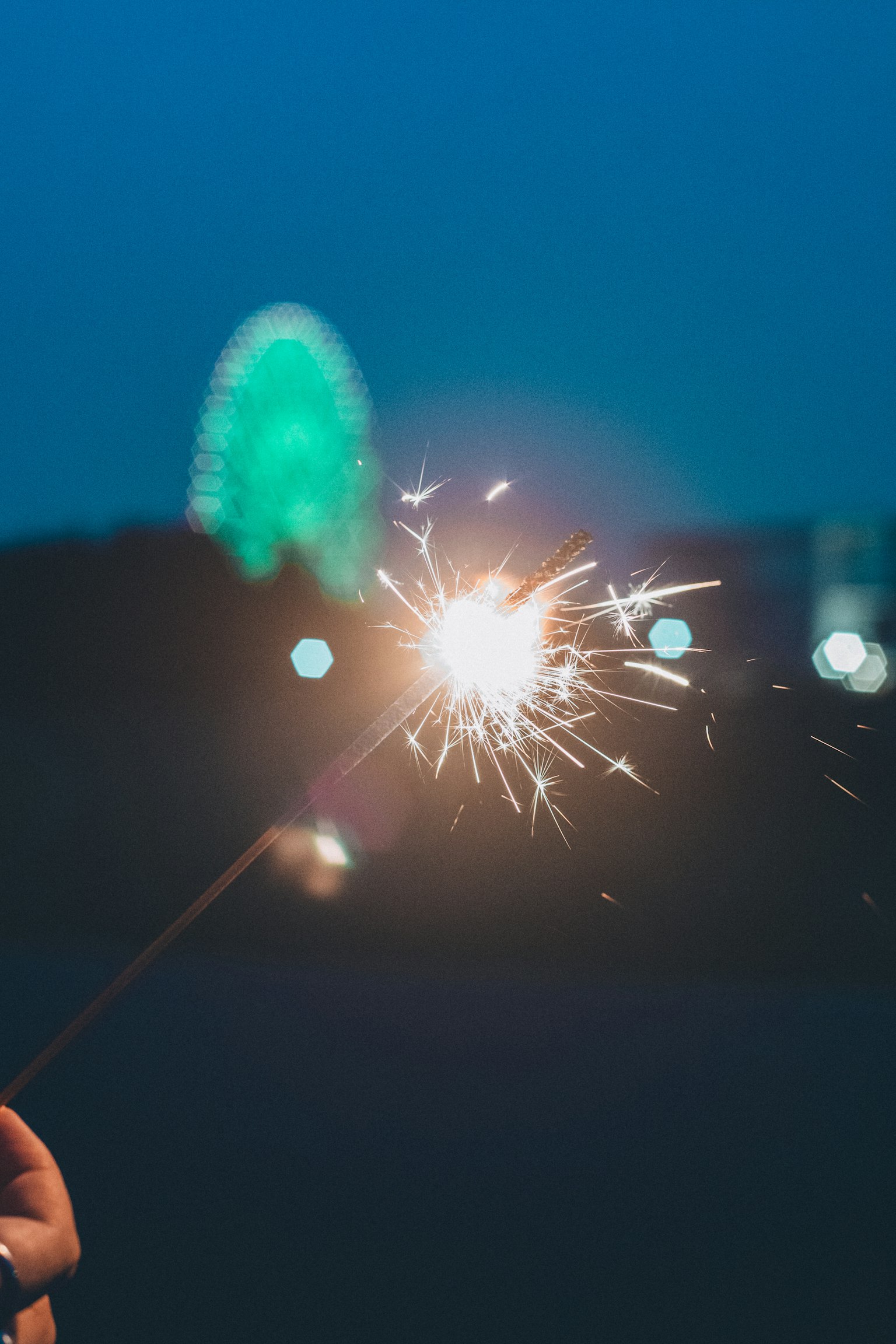 夜空に輝く花火のスパークラーと背景の観覧車
