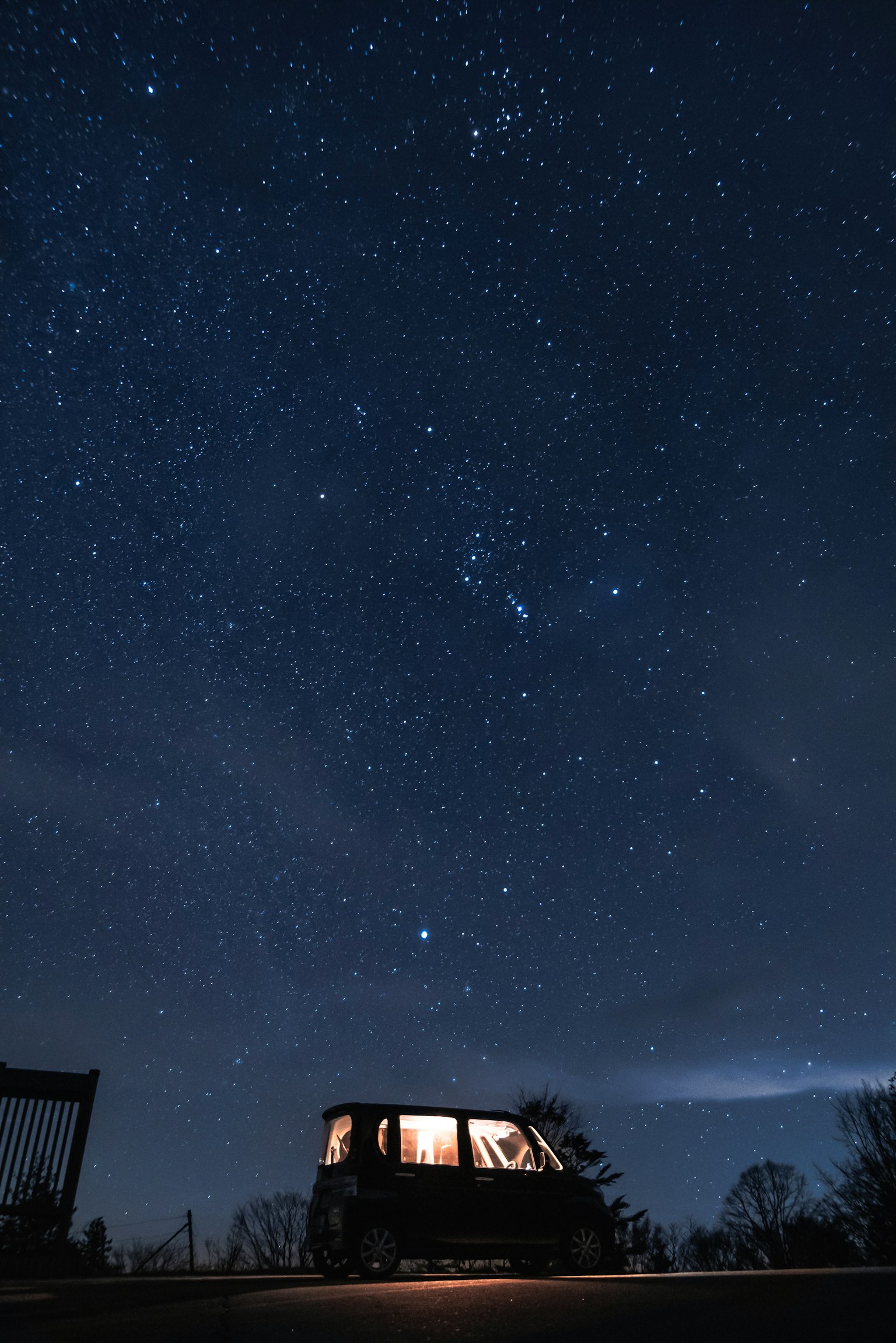 Car parked under a starry sky with numerous stars
