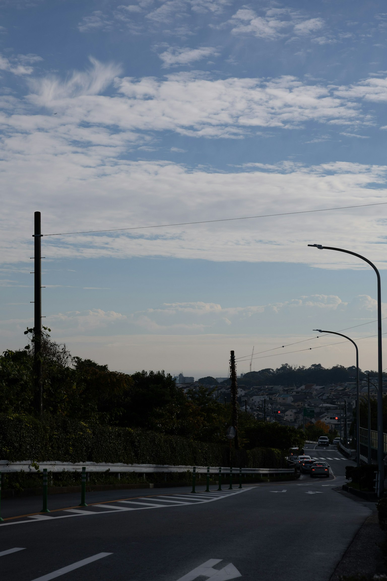Scena stradale con cielo blu e nuvole paesaggio urbano distante visibile