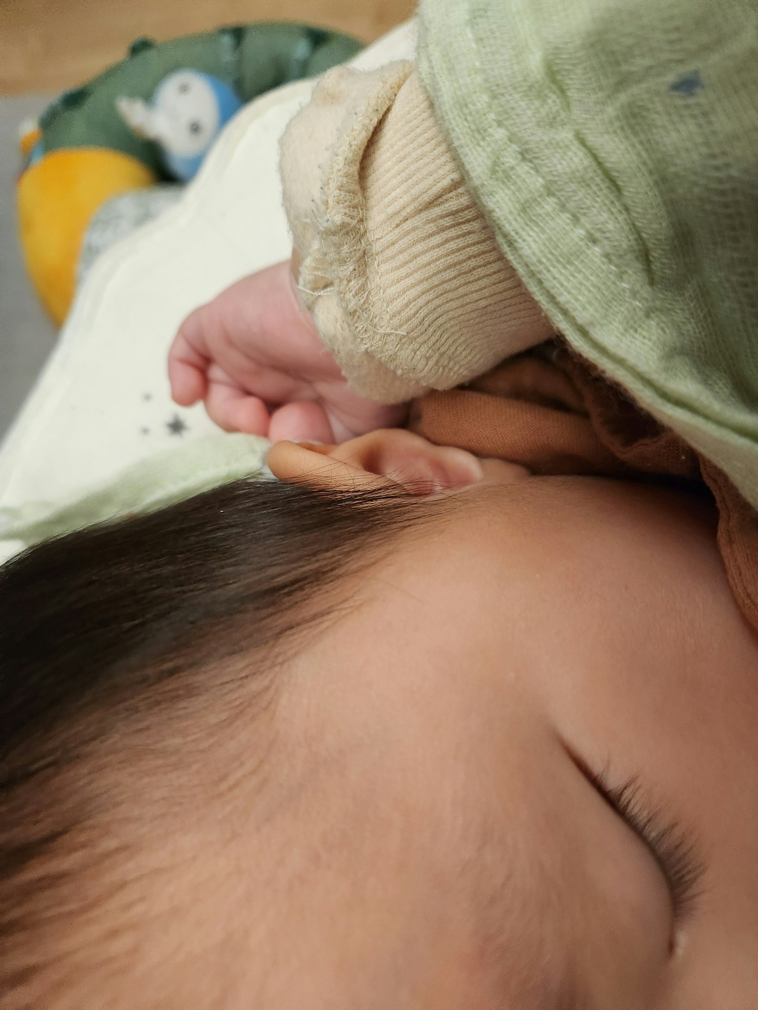 一個睡著的嬰兒，手觸摸著耳朵