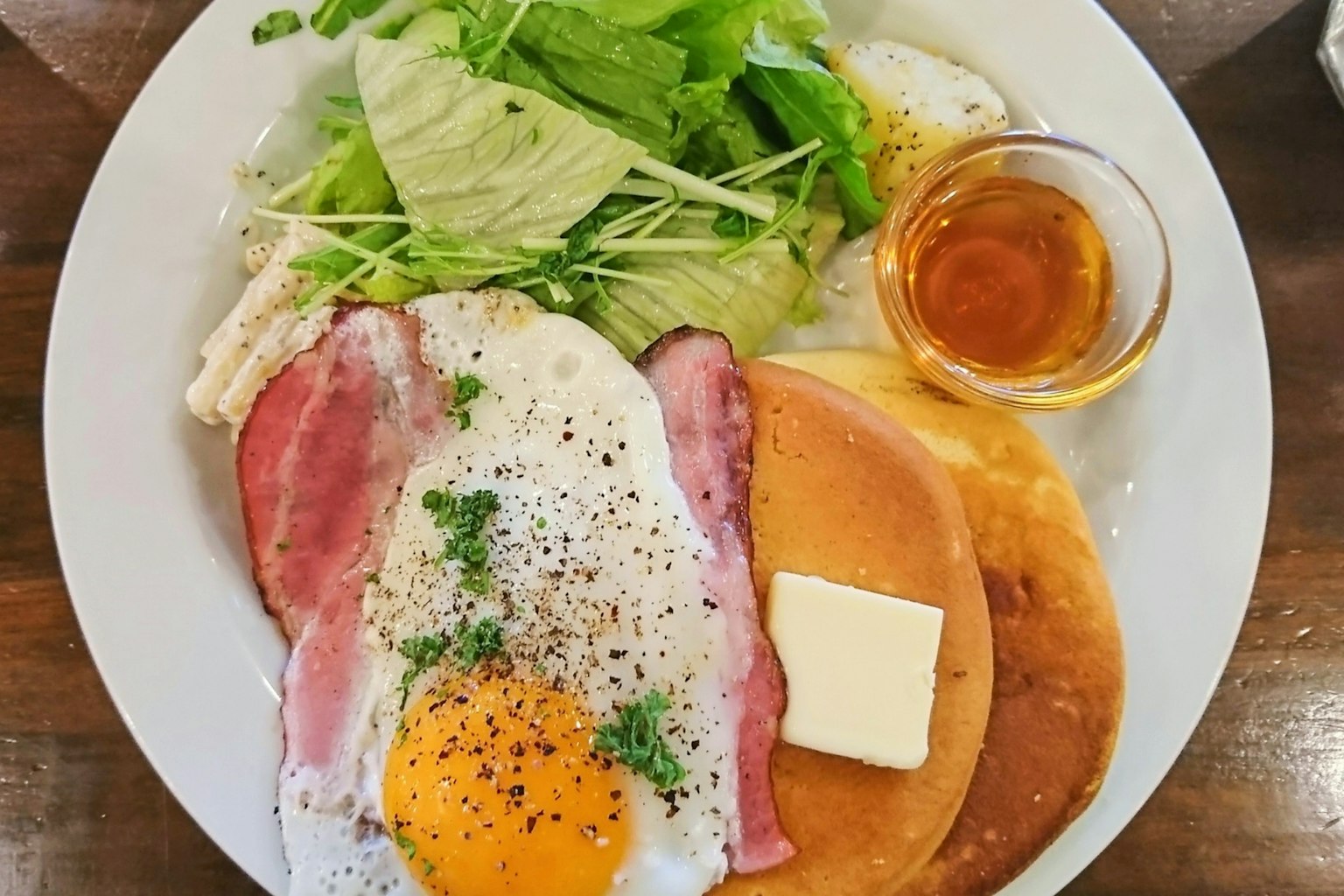 아침 식사 접시에 계란 프라이, 베이컨, 팬케이크, 버터, 샐러드, 시럽