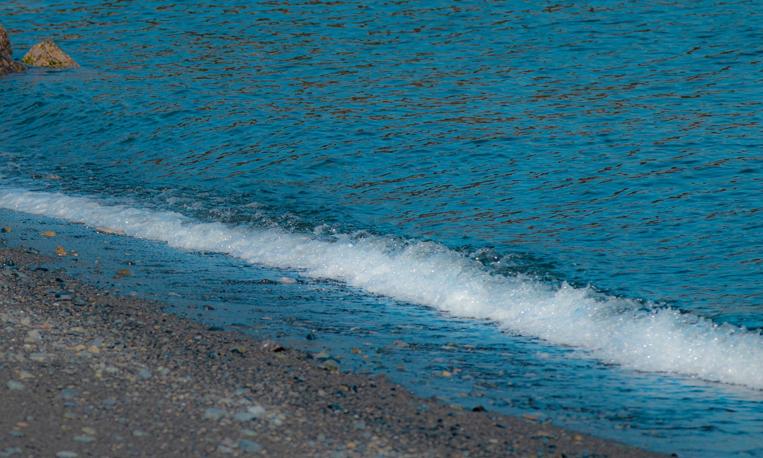 Scena di spiaggia calma con acqua blu e onde leggere
