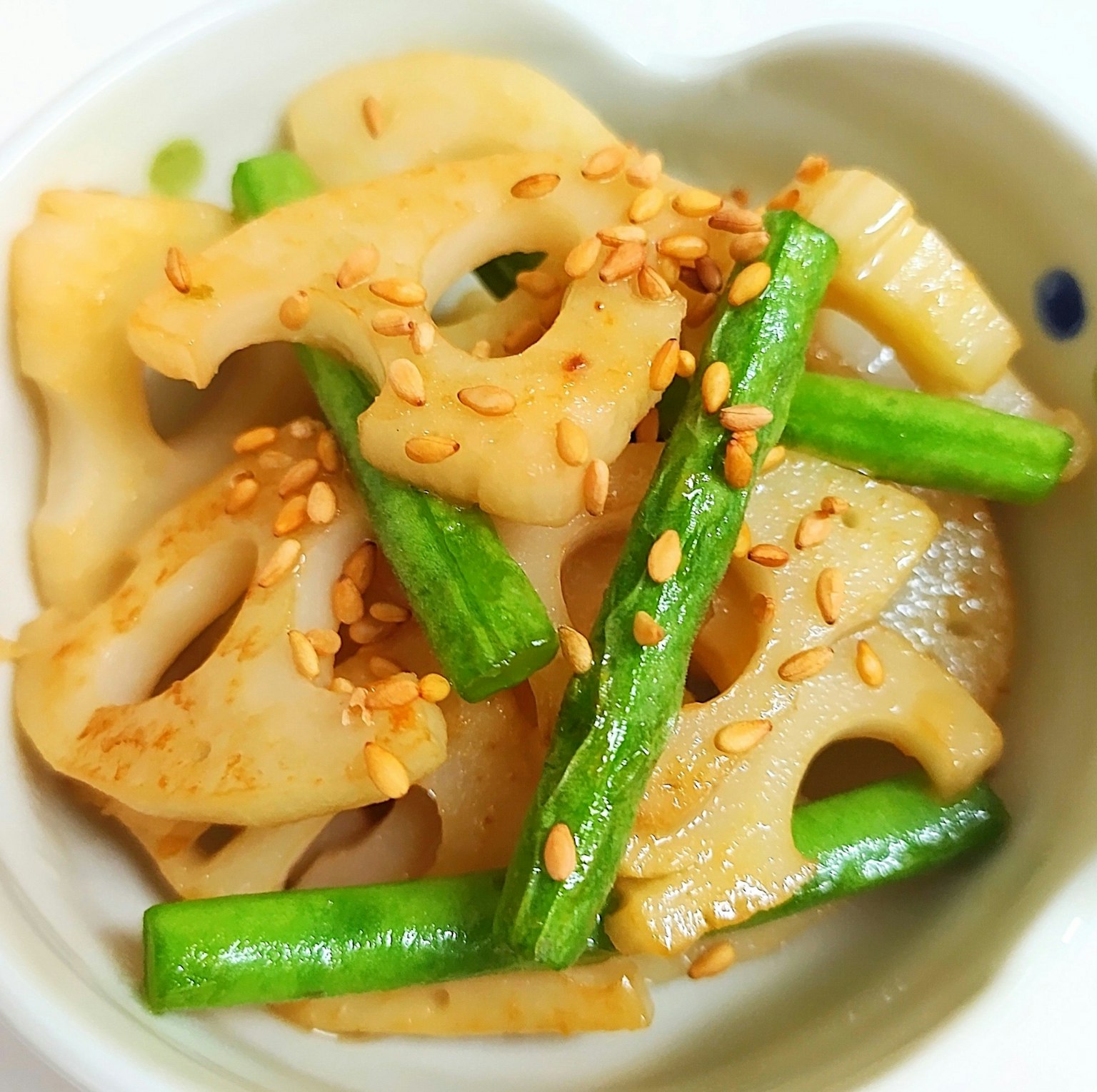 一道配有芝麻的莲藕和青豆的菜肴