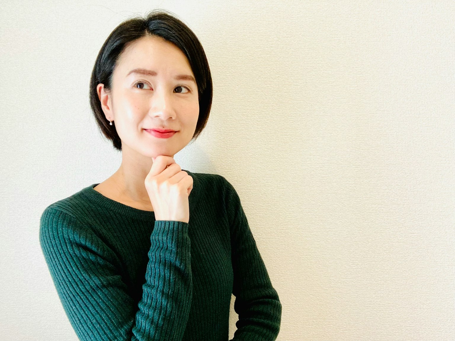 Donna che pensa indossando un maglione verde