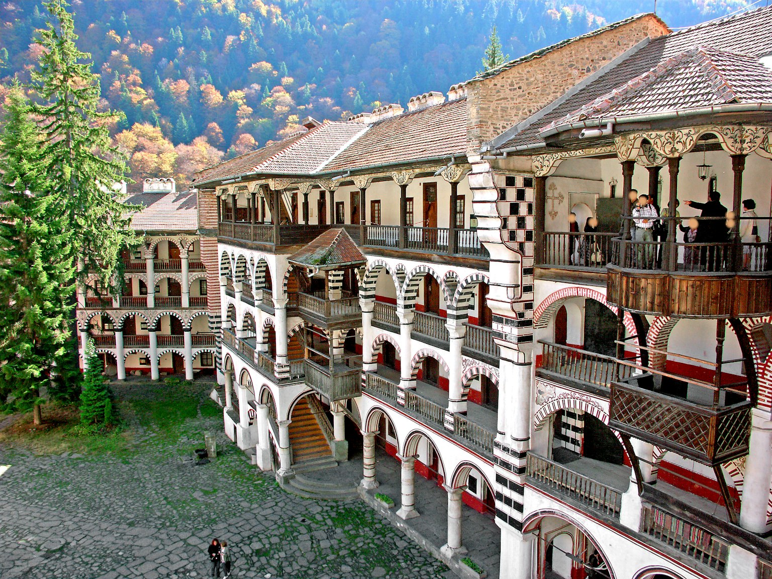 Malerscher Blick auf einen Innenhof mit einzigartigen architektonischen Stilen und umliegenden Bäumen